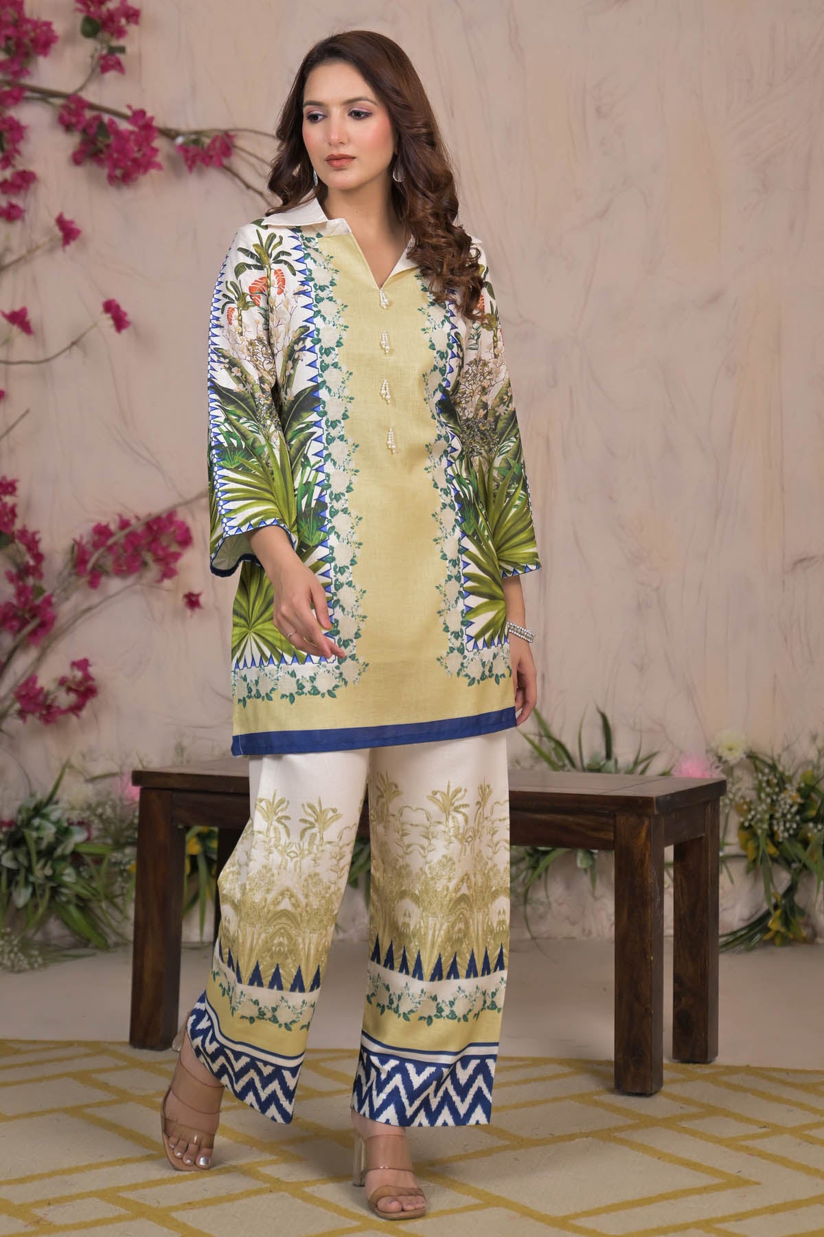 Woman wearing a patterned outfit with floral design in a decorated indoor setting