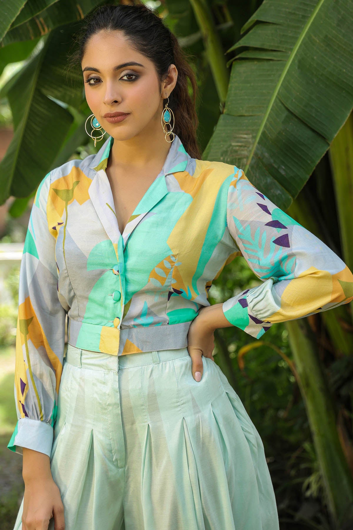 Woman wearing a colorful shirt with a blurred green leafy background