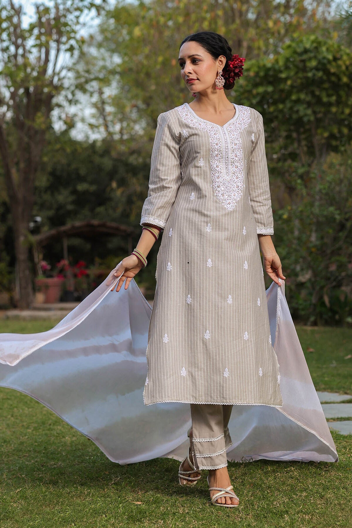 Woman in a traditional outfit with a flowing fabric in an outdoor setting