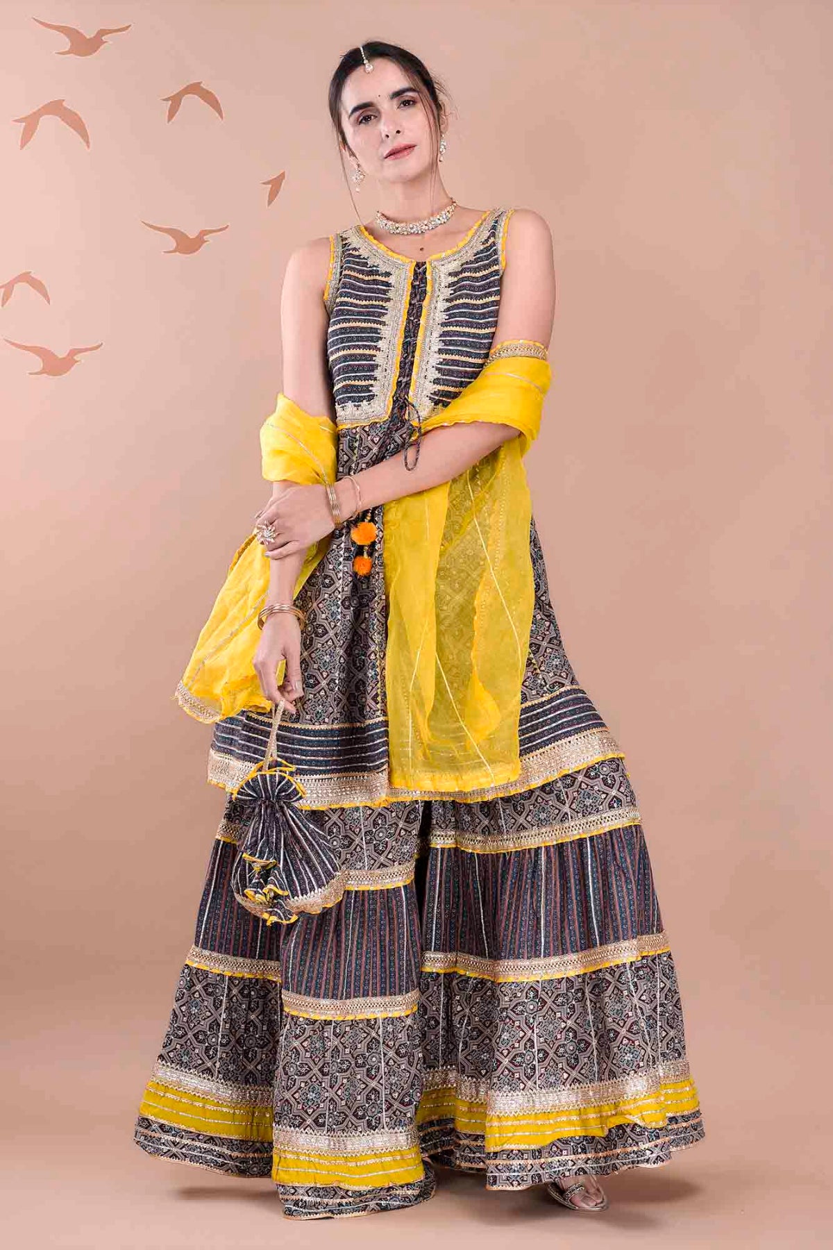 Woman wearing a traditional outfit with yellow and black patterns on a beige background