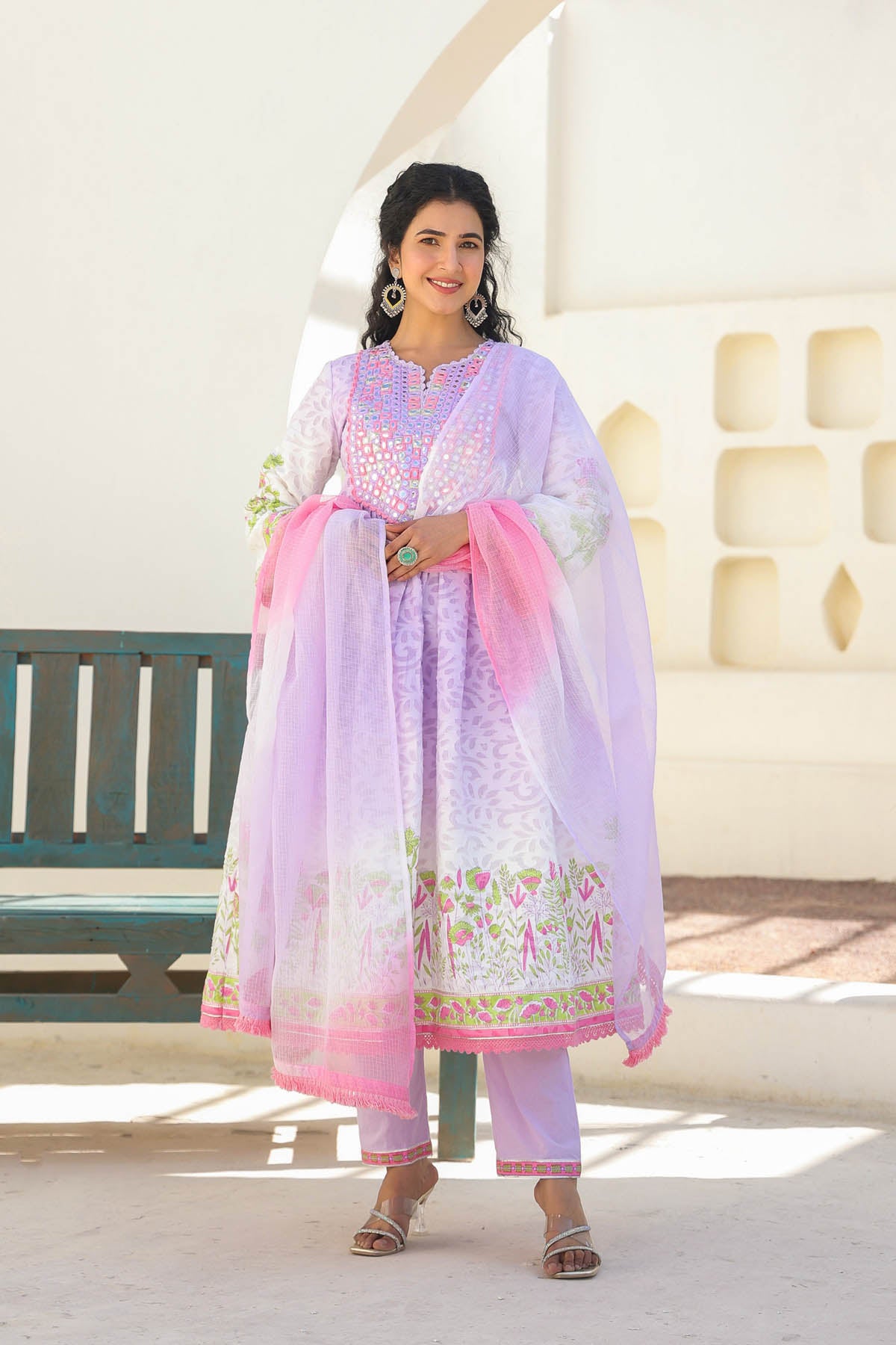 Woman wearing a light purple traditional outfit with pink dupatta in an outdoor setting