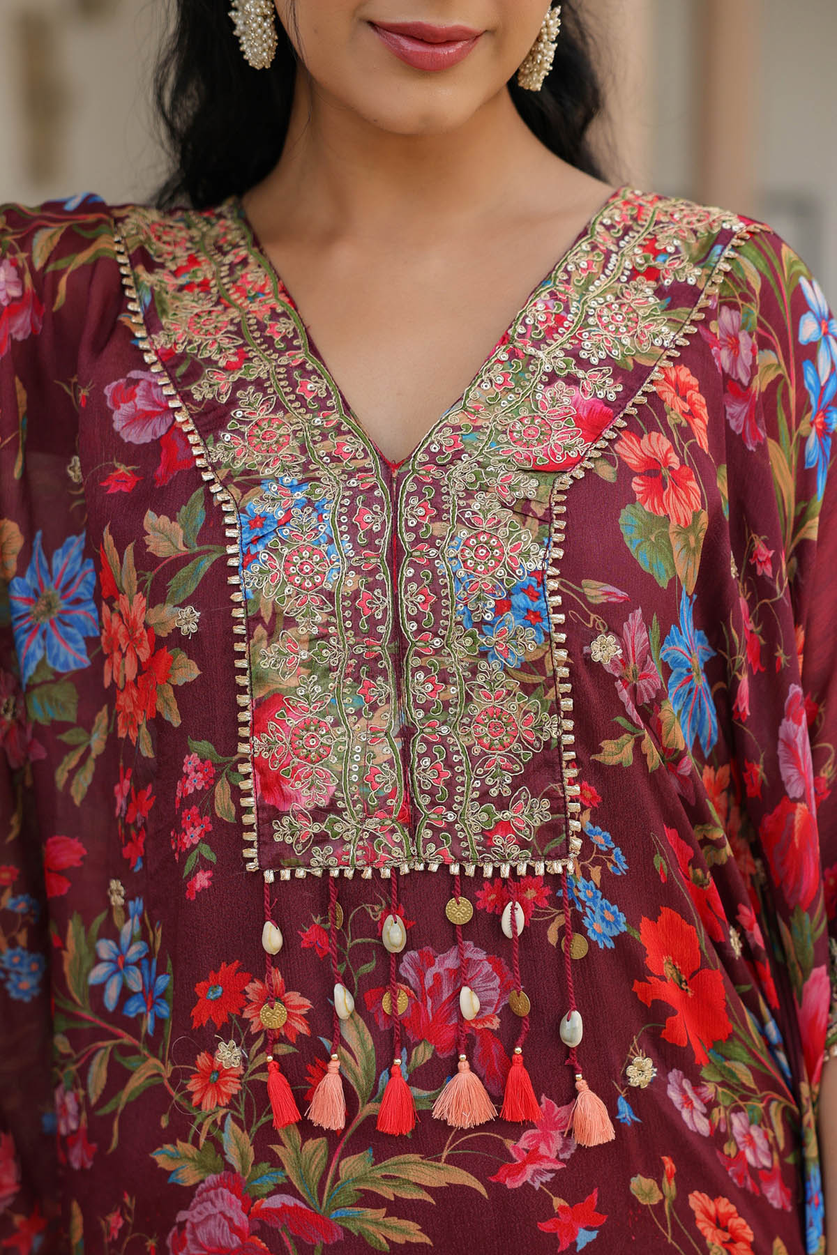 Close-up of a person wearing a colorful floral and embroidered traditional outfit.