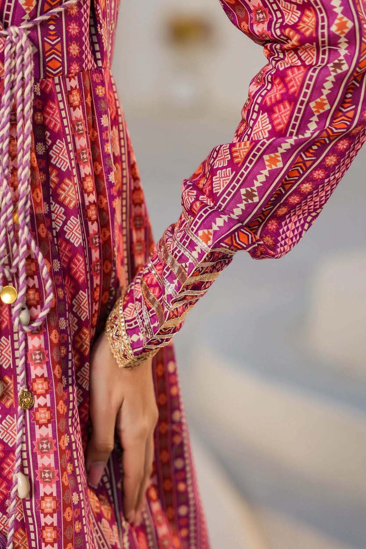 Close-up of a person wearing a vibrant, patterned dress with a blurred background