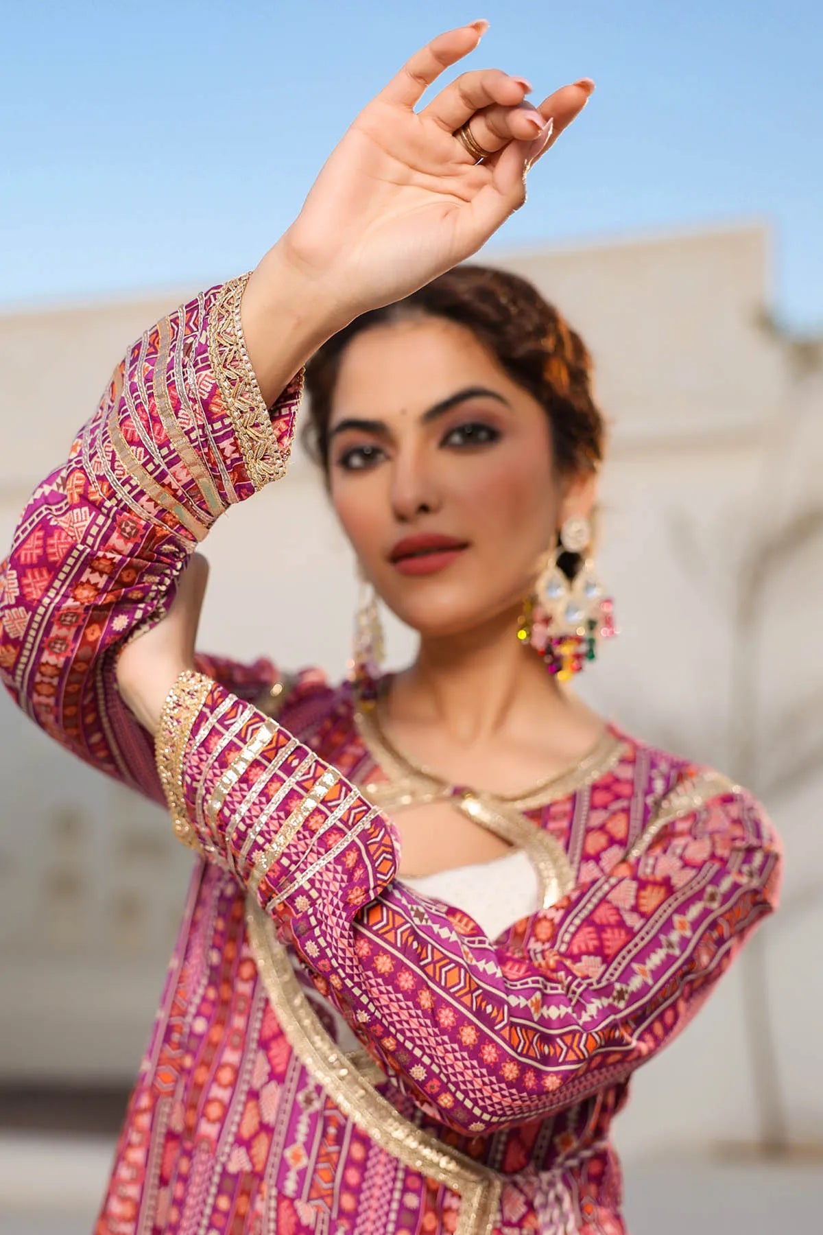 Woman wearing a traditional patterned outfit with a blurred background