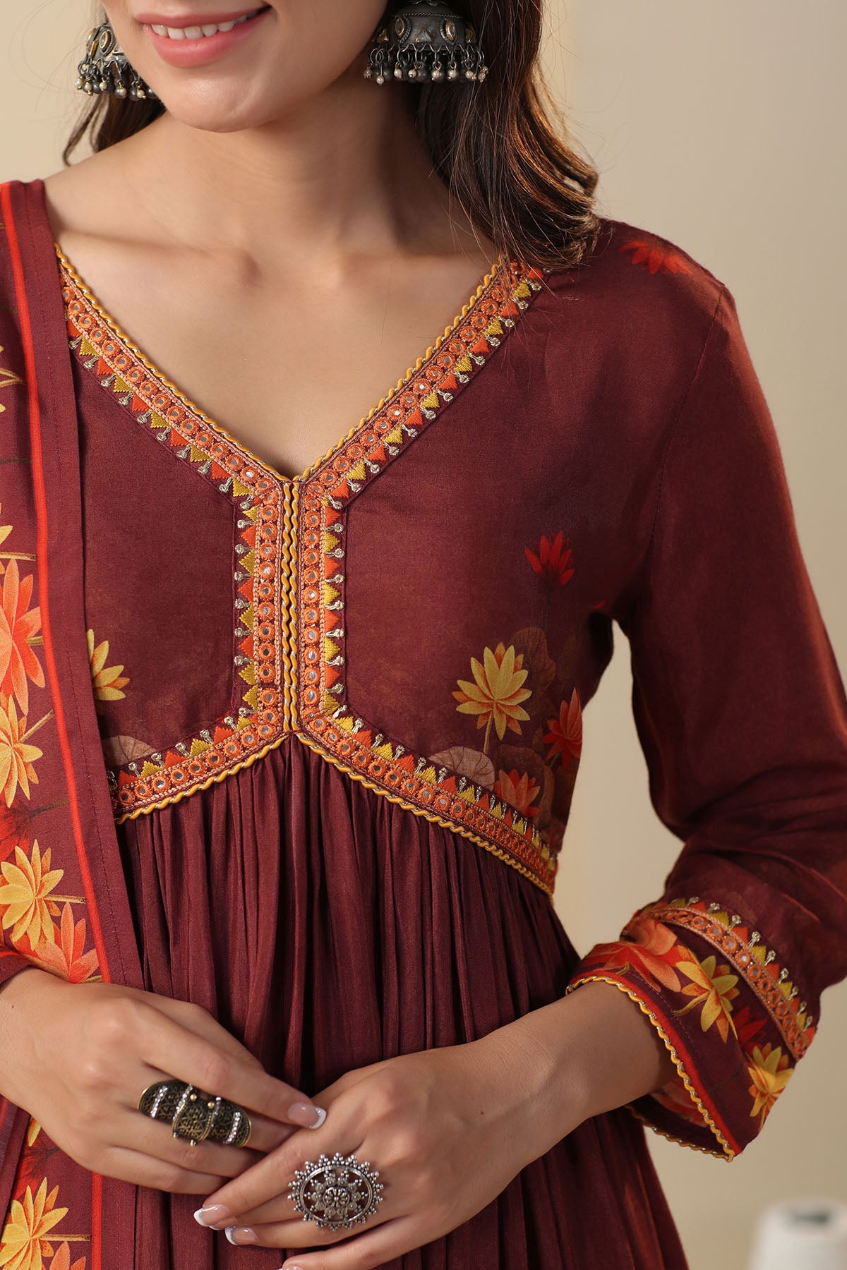Maroon traditional outfit with intricate embroidery and a matching shawl.