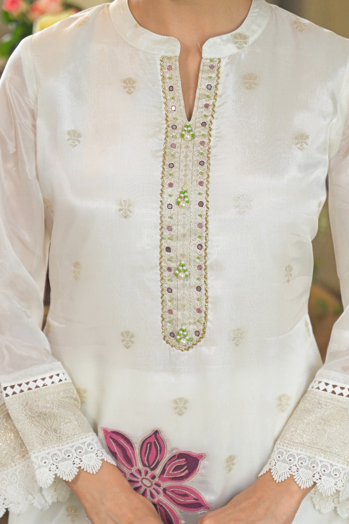 White embroidered kurta with floral patterns on a blurred background