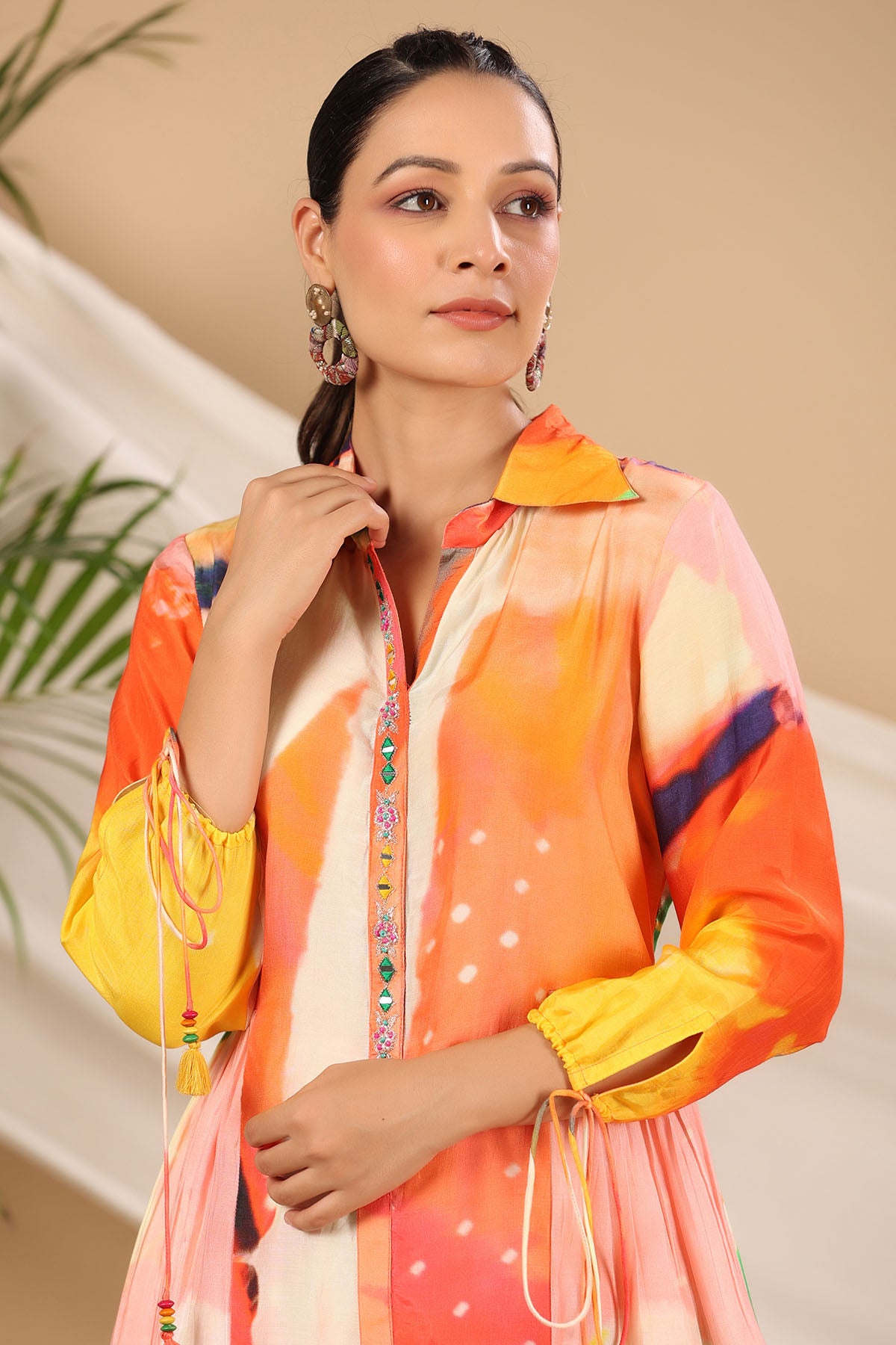 Woman wearing a colorful traditional outfit with a neutral background