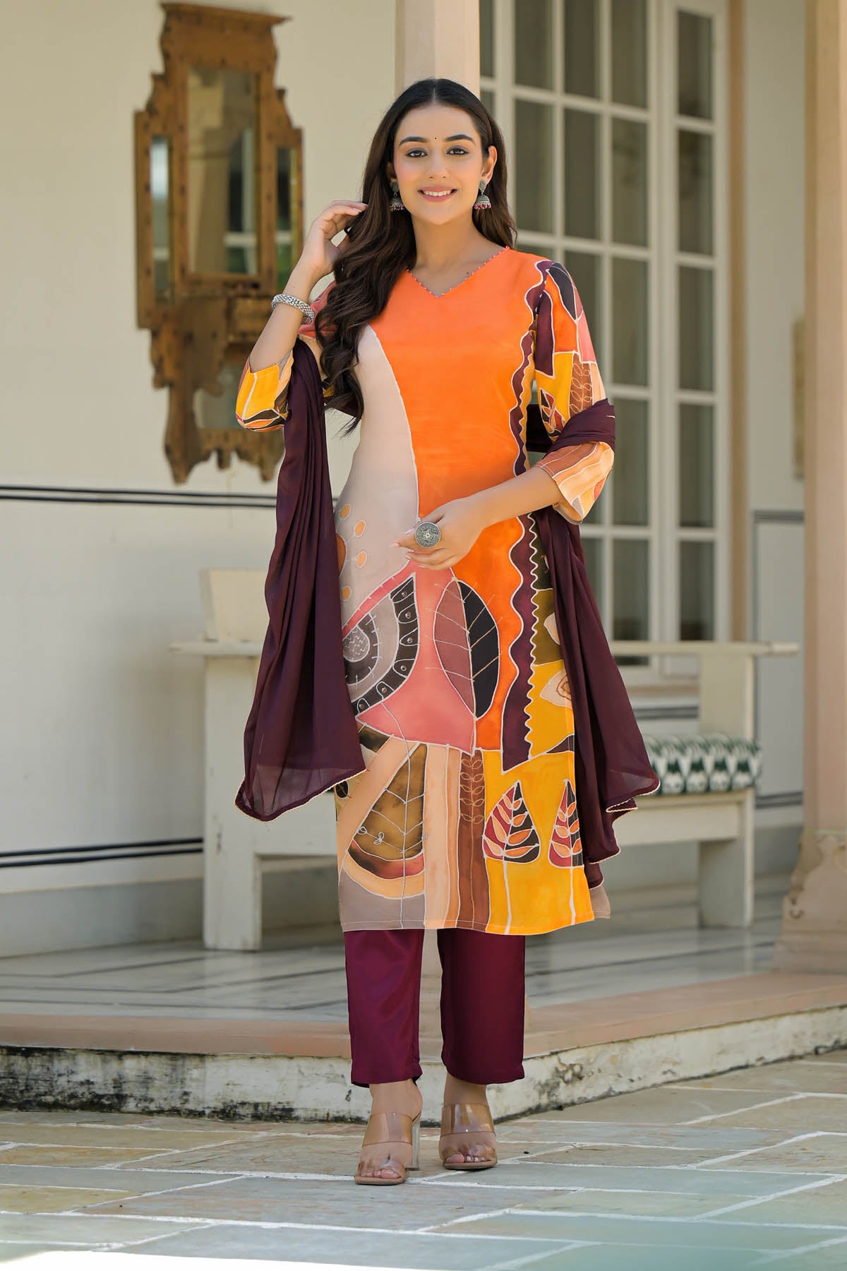 Woman in a colorful outfit standing in an outdoor setting.
