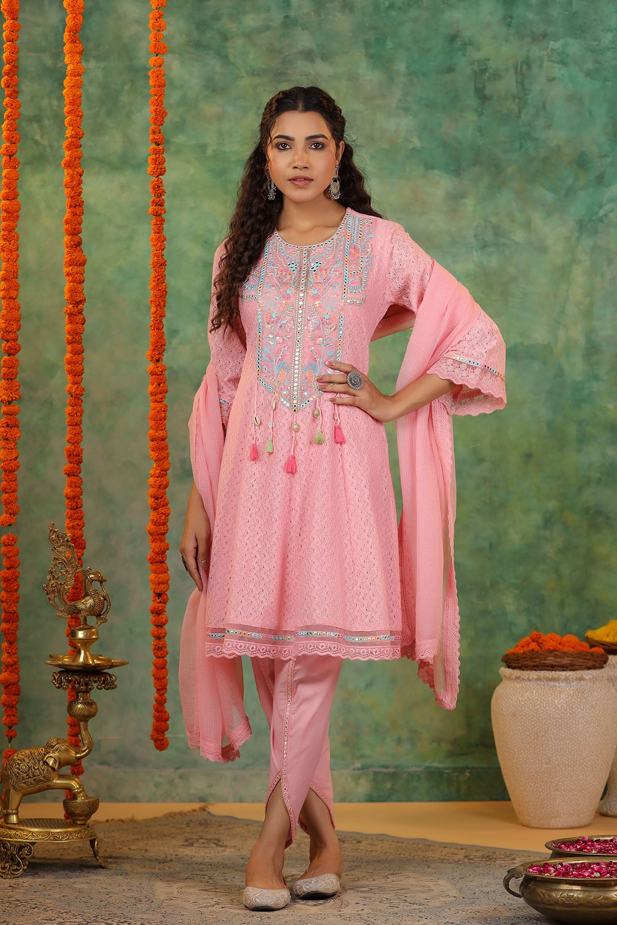 Woman in a pink traditional outfit with a green textured background