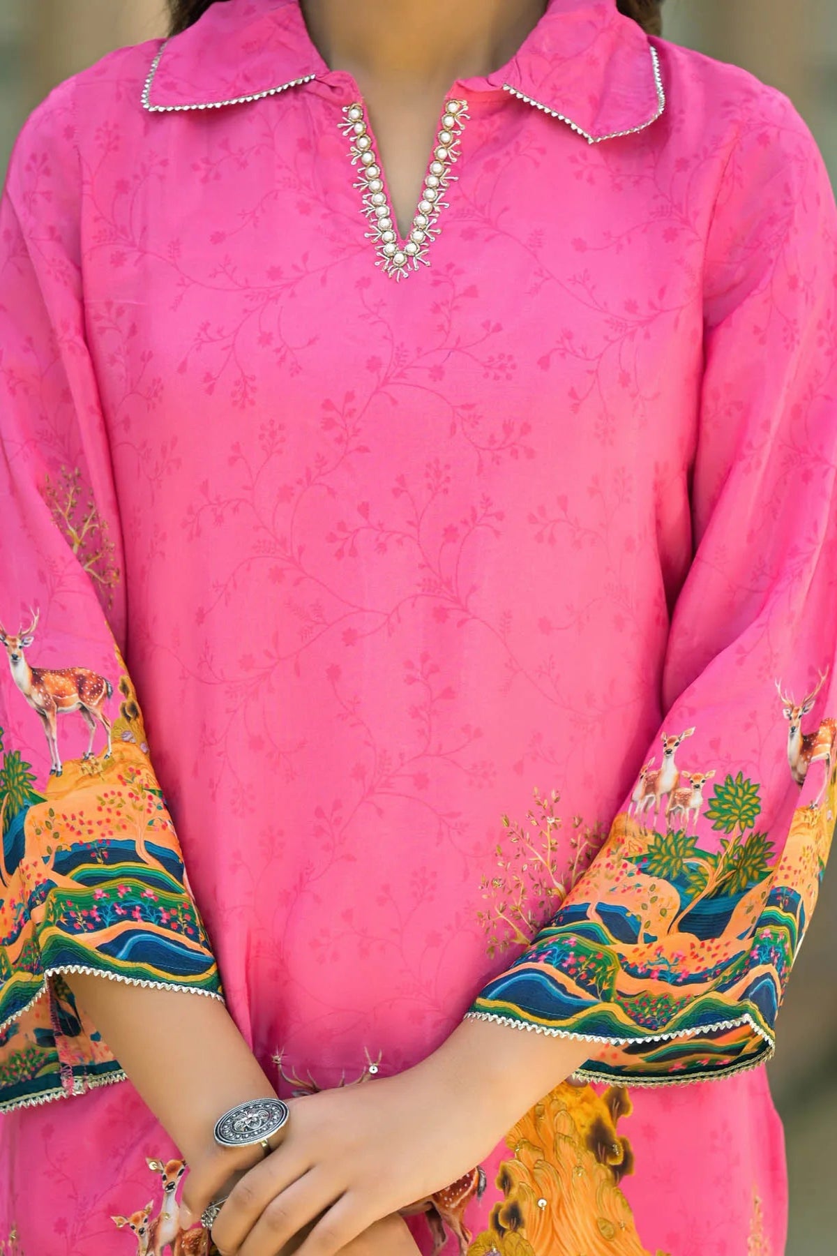 Pink traditional outfit with colorful patterns on sleeves and collar front 