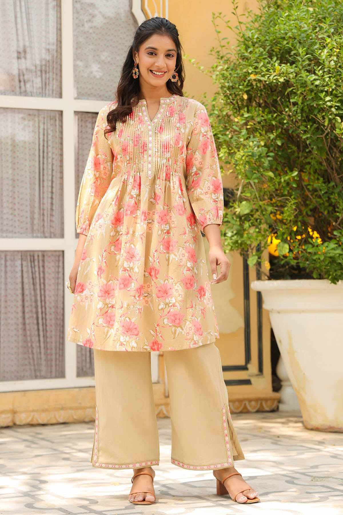 Woman wearing a floral kurta with beige pants outdoors.