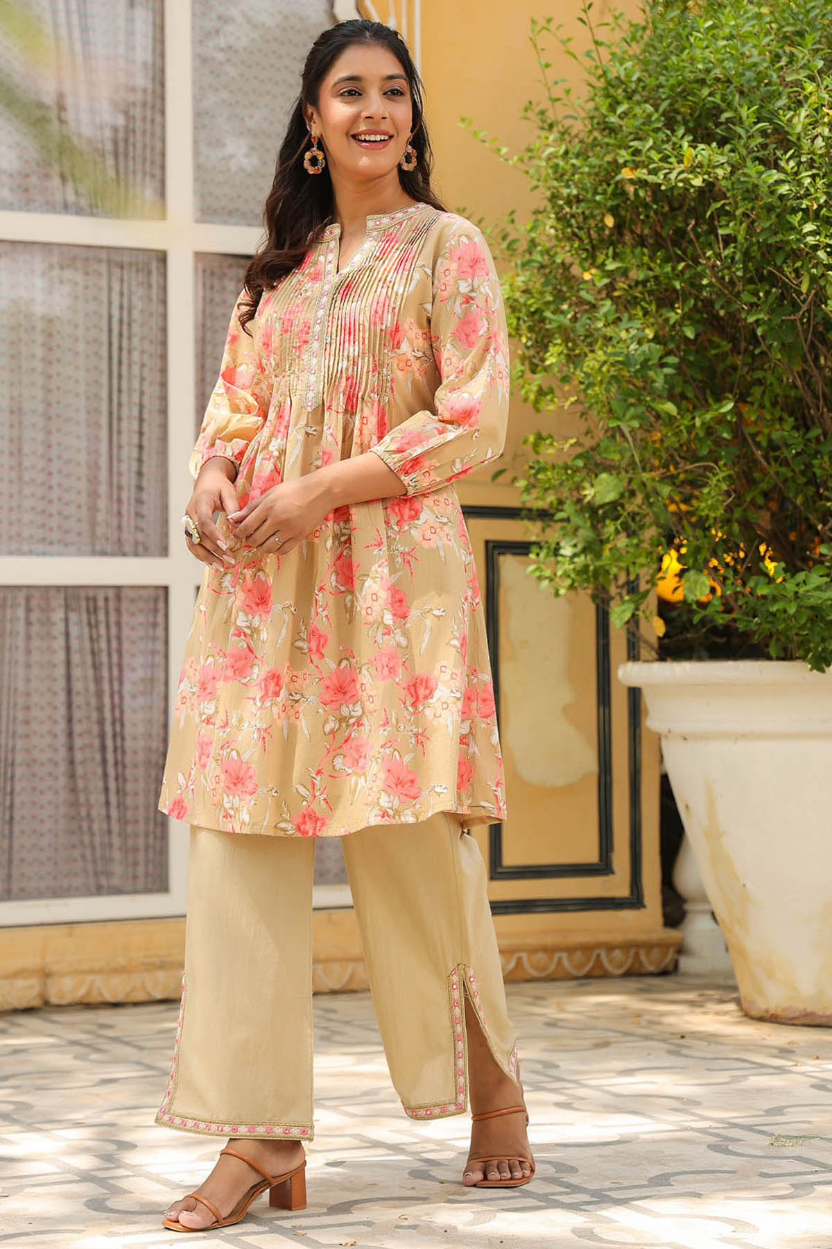 Woman wearing a floral kurta with palazzo pants in an outdoor setting.
