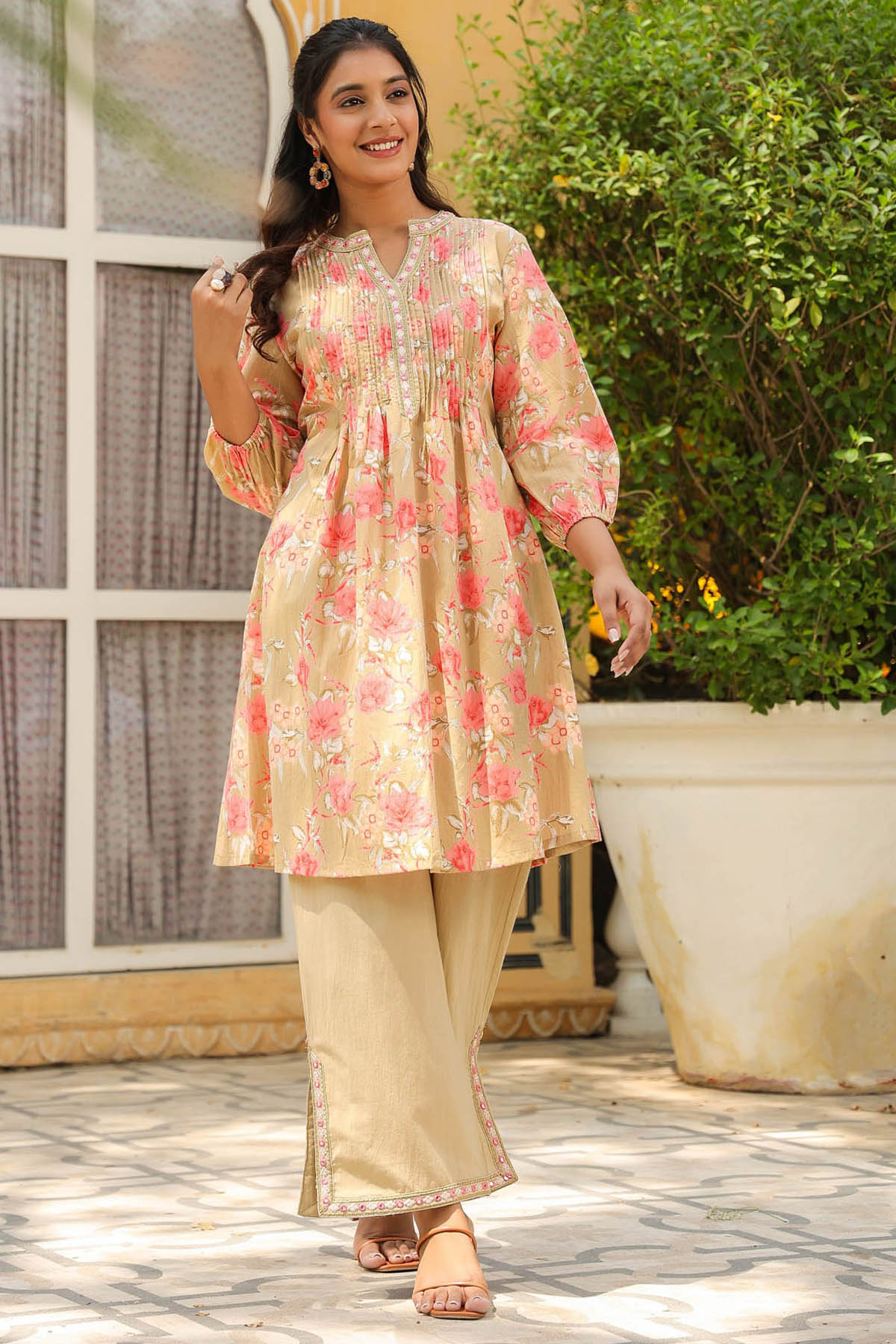 Woman wearing a floral kurta with beige pants outdoors.