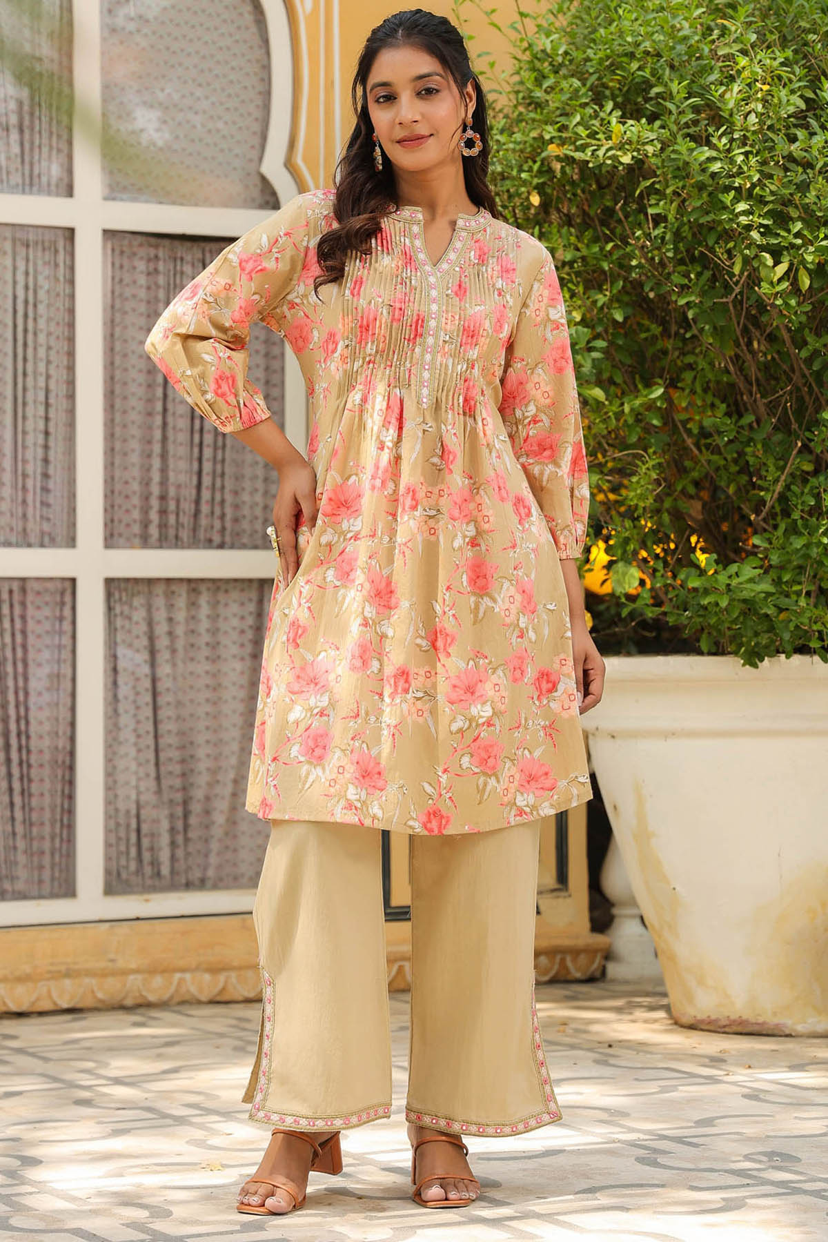 Woman wearing a floral kurta with beige pants outdoors.