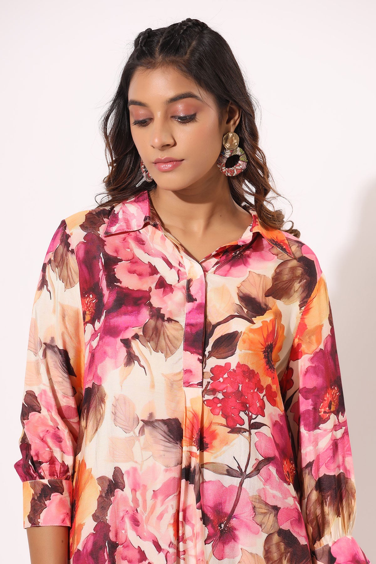 Woman wearing a colorful floral shirt against a white background