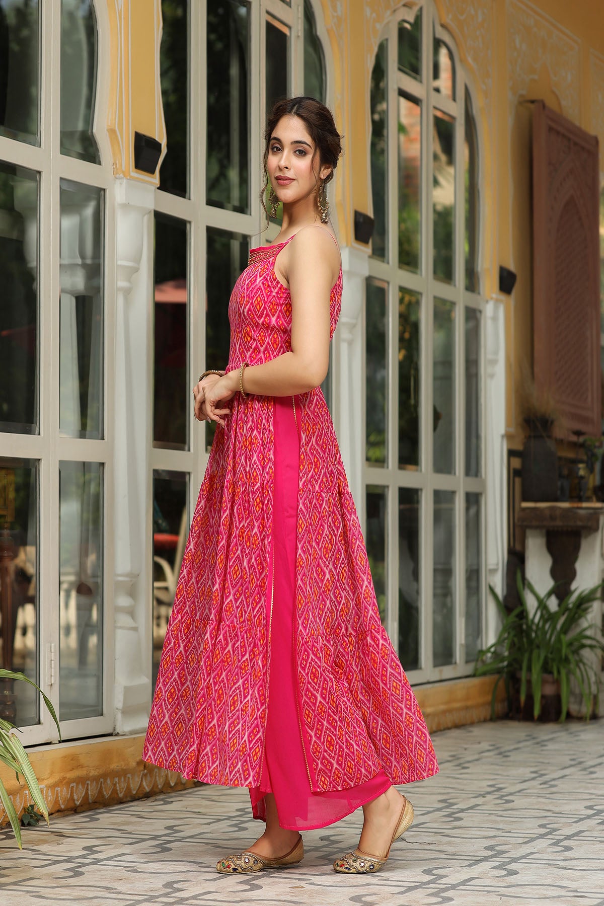 Woman in a pink dress standing in front of a glass door.