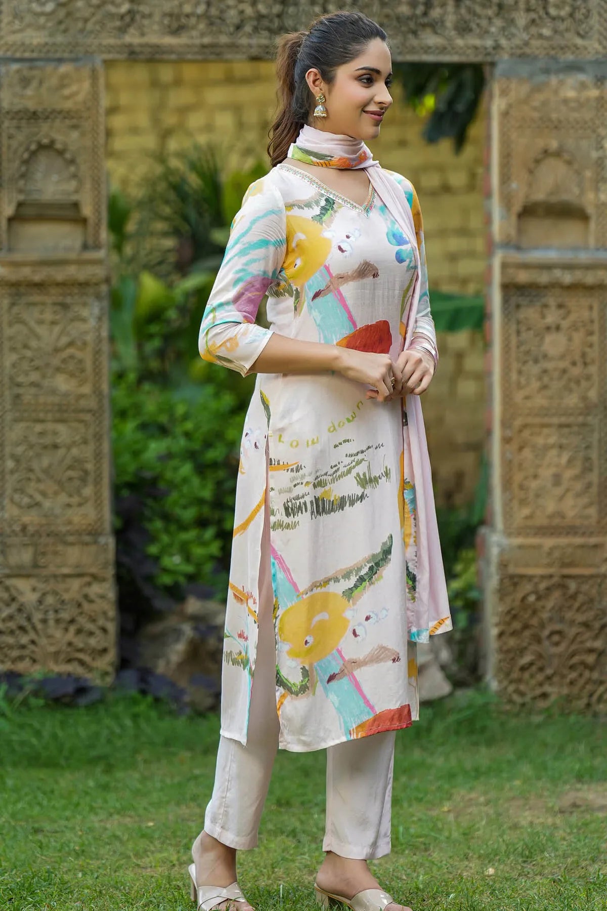 Woman wearing a colorful kurta with a traditional design in an outdoor setting.