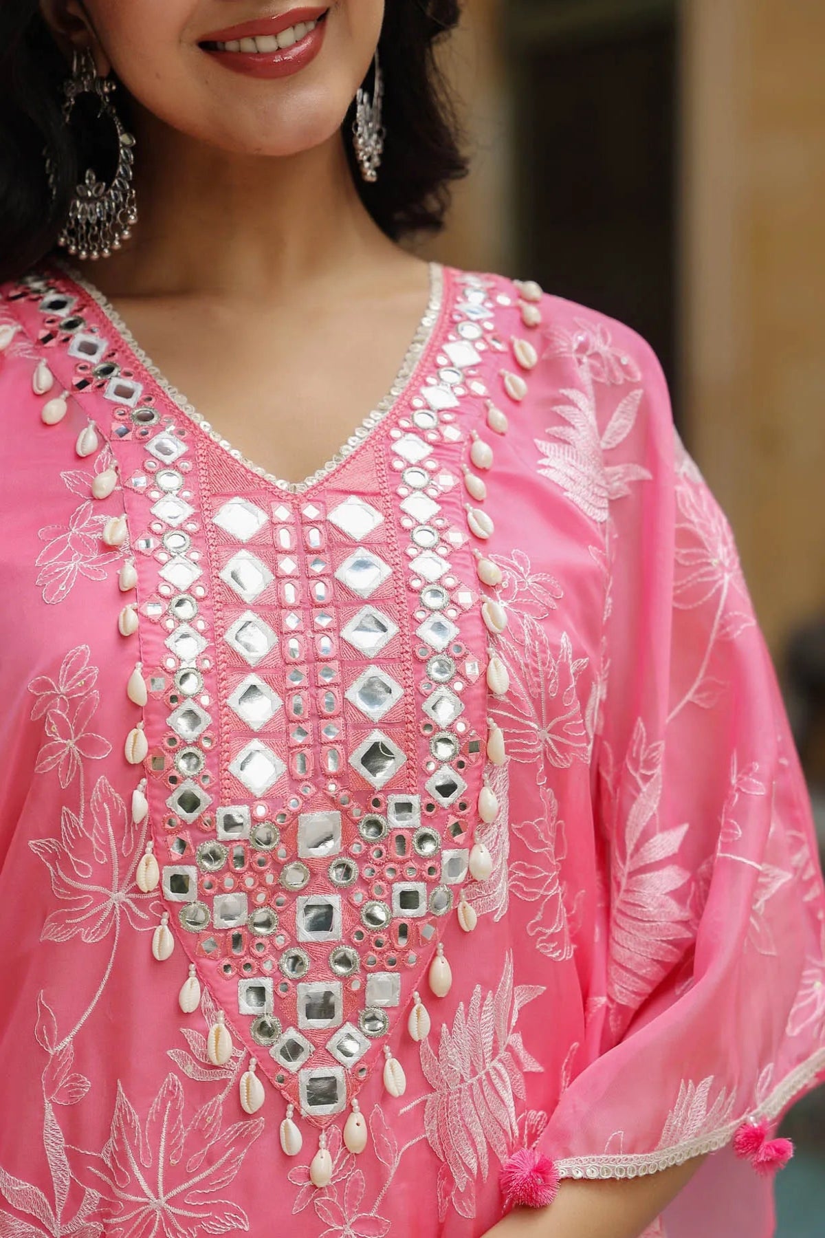 Woman wearing a pink embroidered dress with silver details