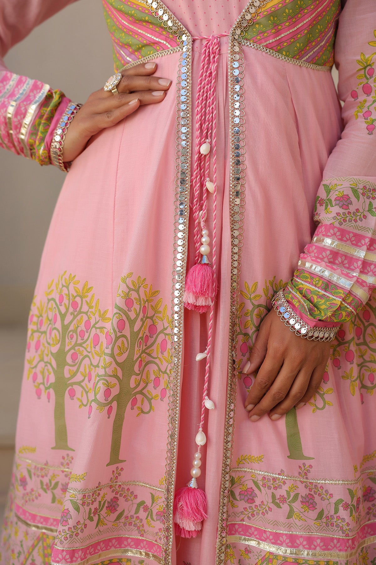 Pink traditional outfit with floral patterns and tassels