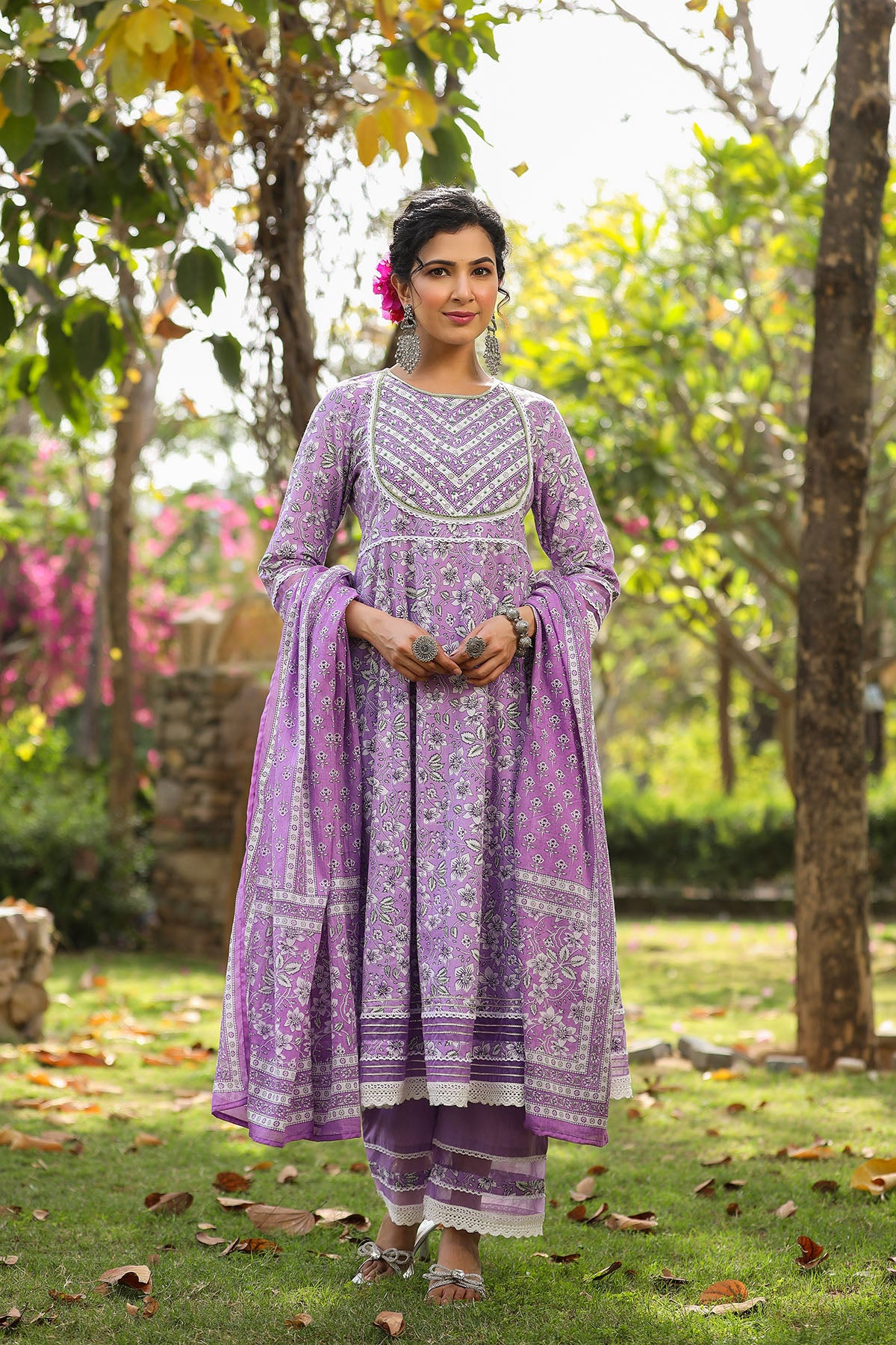 Woman in a purple traditional outfit standing in a garden