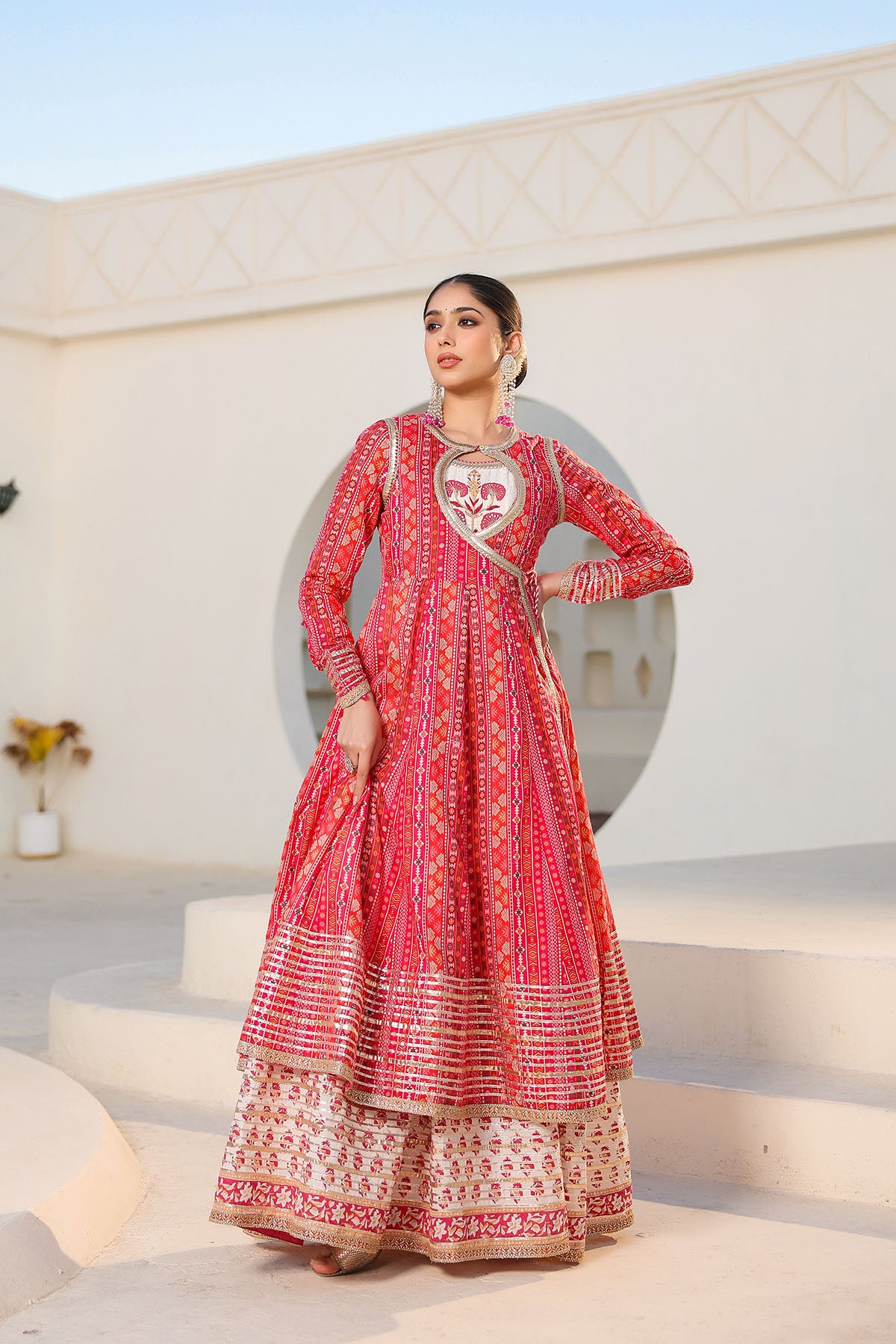 Woman wearing a red and white patterned traditional outfit on a light background