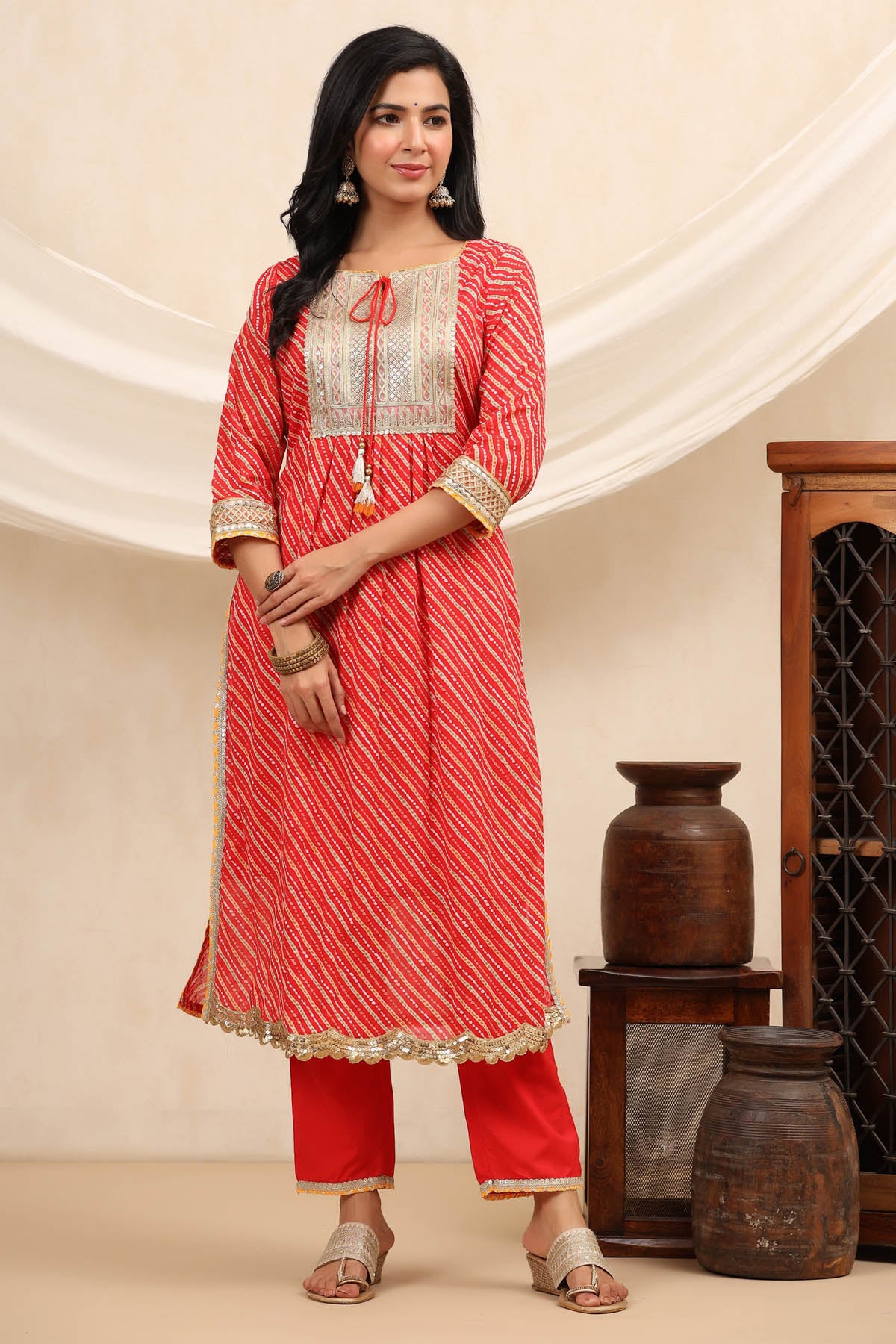 Woman wearing a red and white traditional outfit with a neutral background