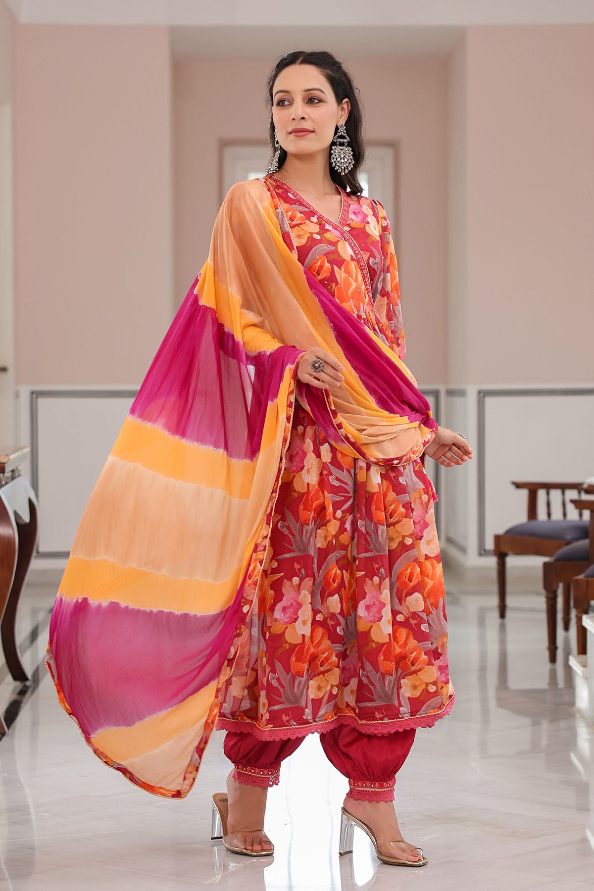 Woman wearing a traditional outfit with a colorful dupatta in an indoor setting