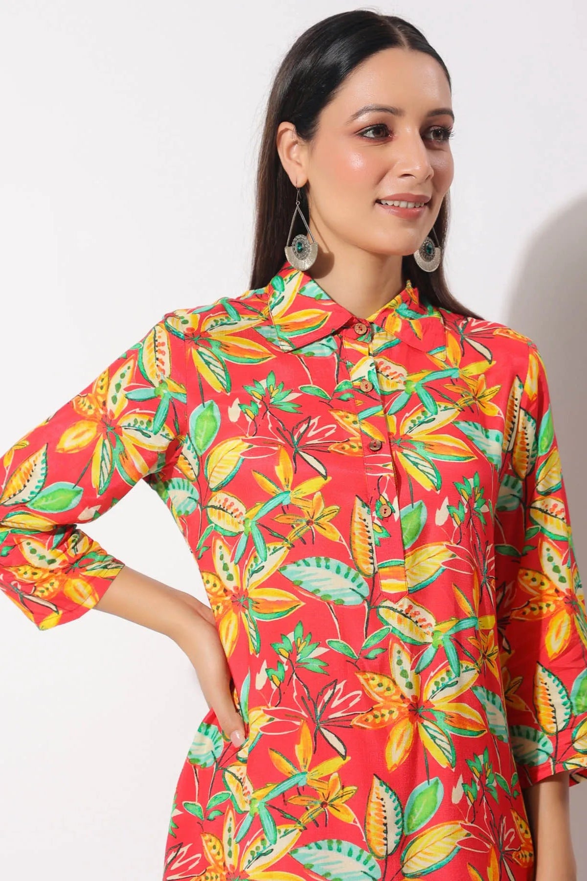 Woman wearing a red floral patterned shirt against a white background