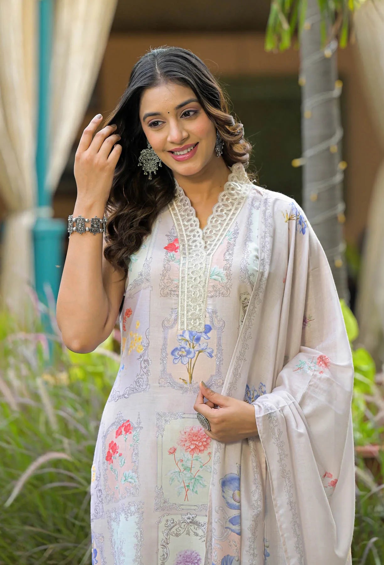 Woman wearing a floral dress with a beige dupatta in an outdoor setting