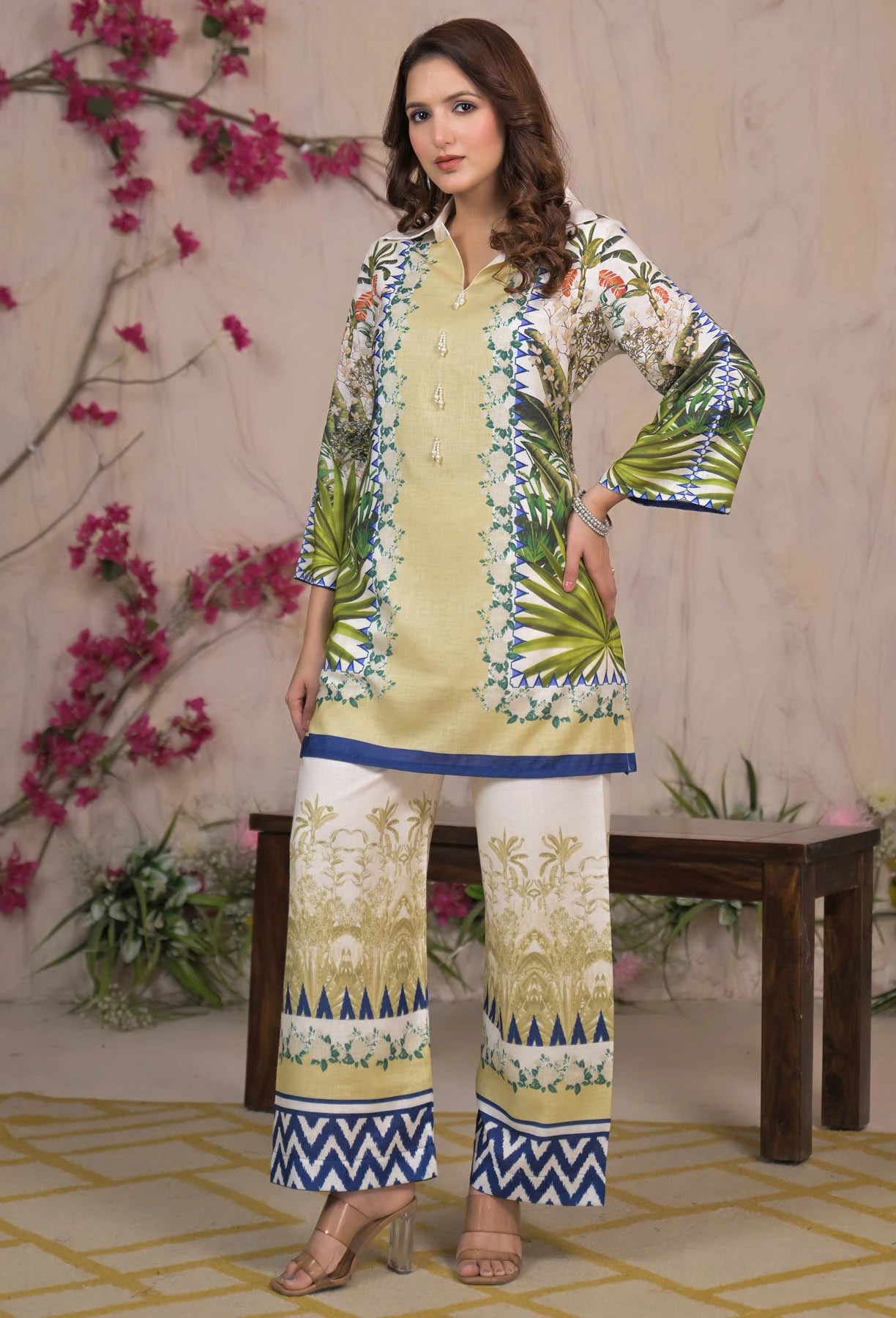 Woman wearing a colorful traditional outfit with floral patterns against a floral background