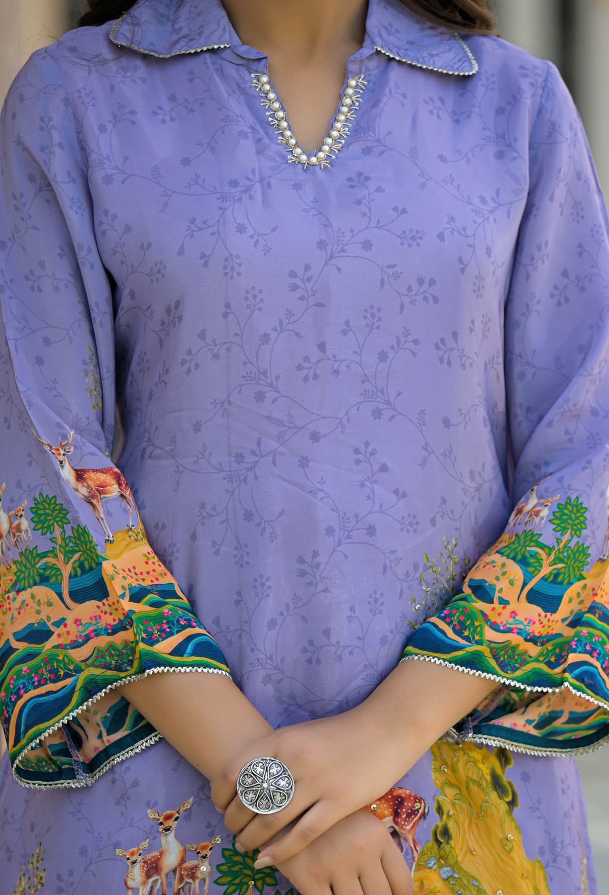 Purple traditional outfit with colorful sleeves and a watch on a wrist.