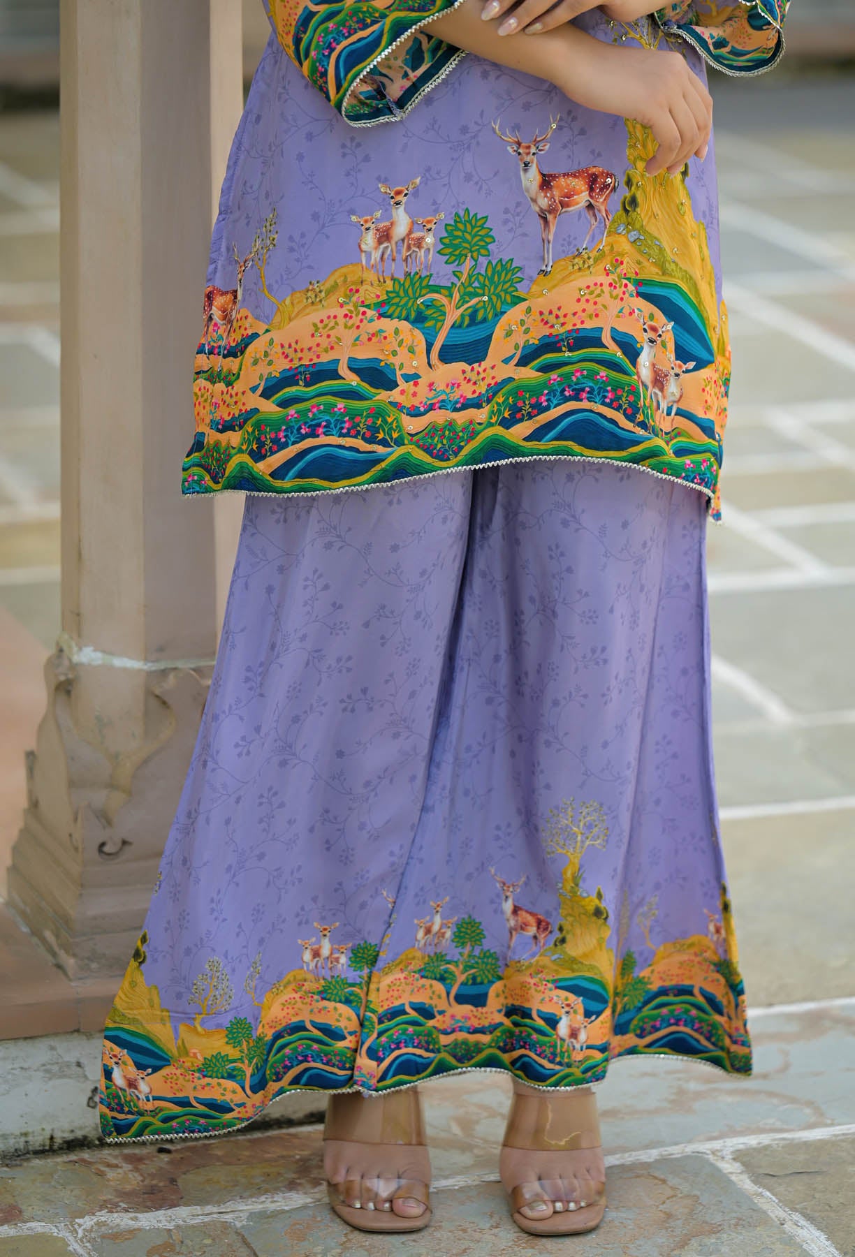 Traditional outfit with embroidered top and pants on a stone floor.