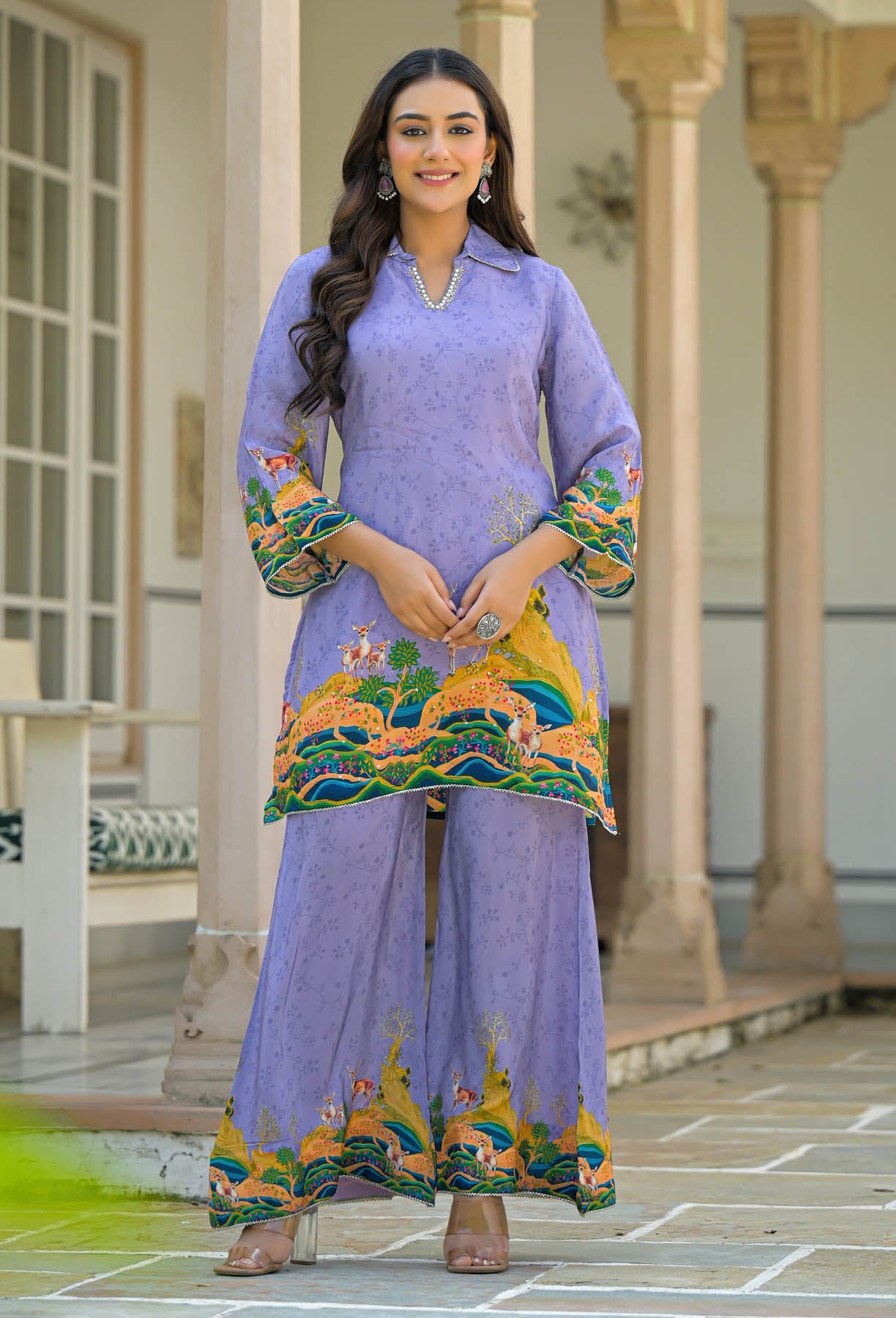 Woman wearing a purple traditional outfit with colorful embroidery in an outdoor setting.