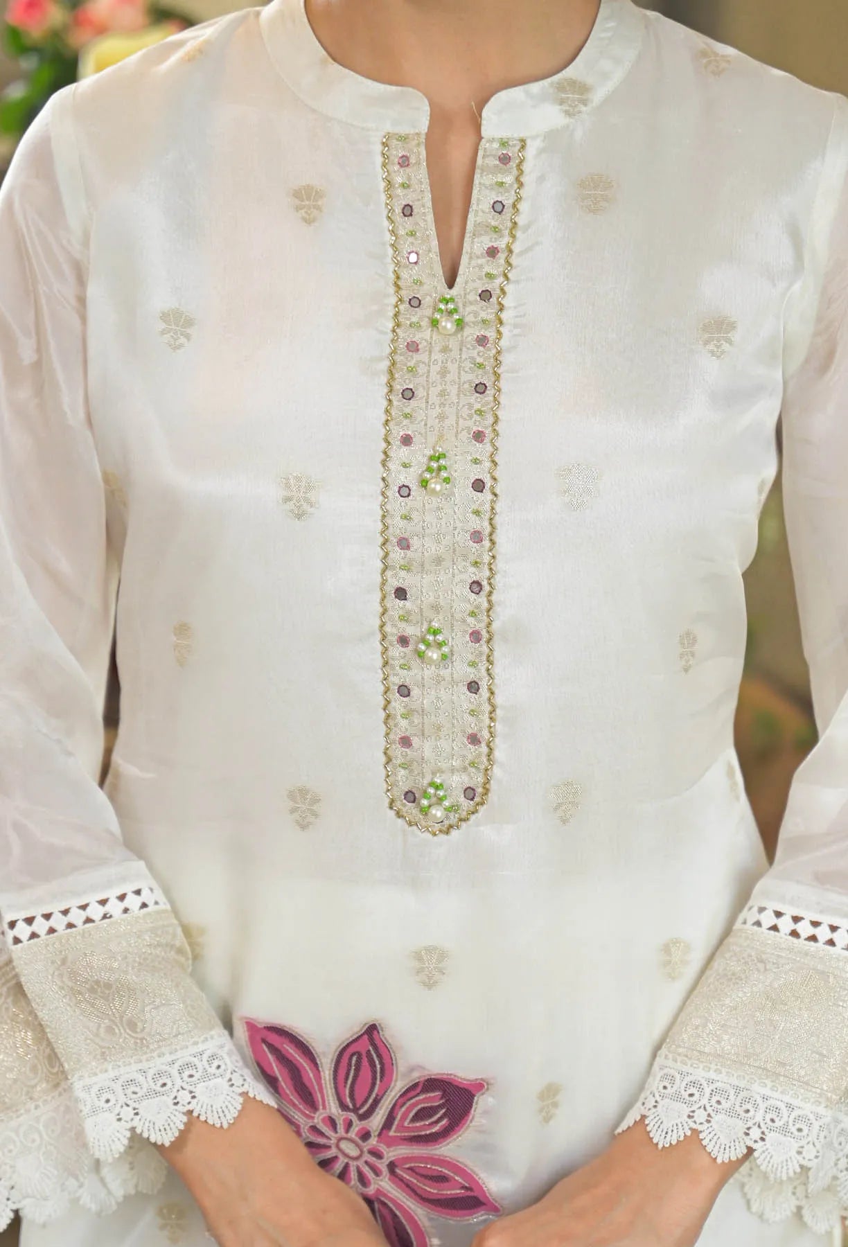 White embroidered kurta with floral design on a blurred background