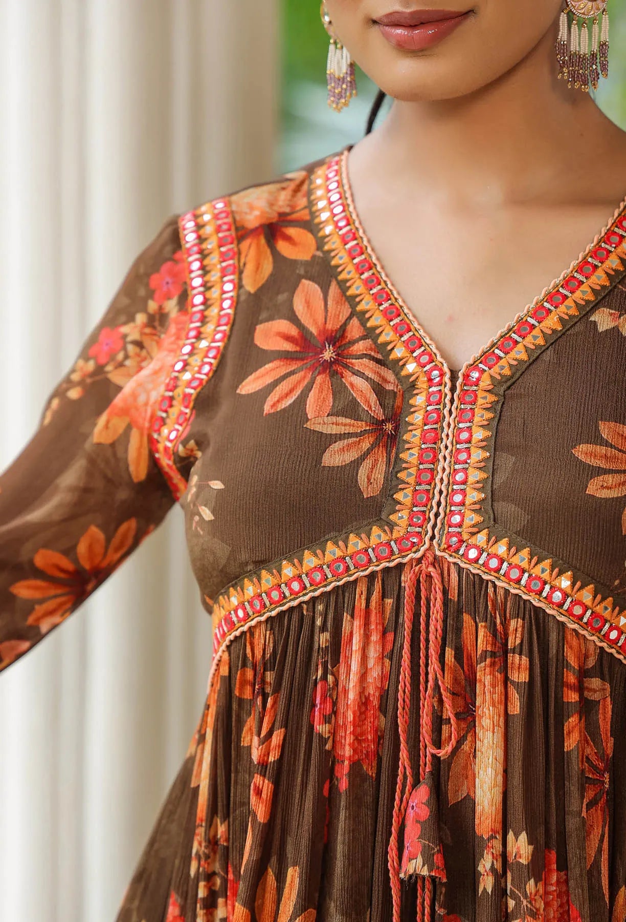 Woman wearing a brown floral dress with intricate detailing