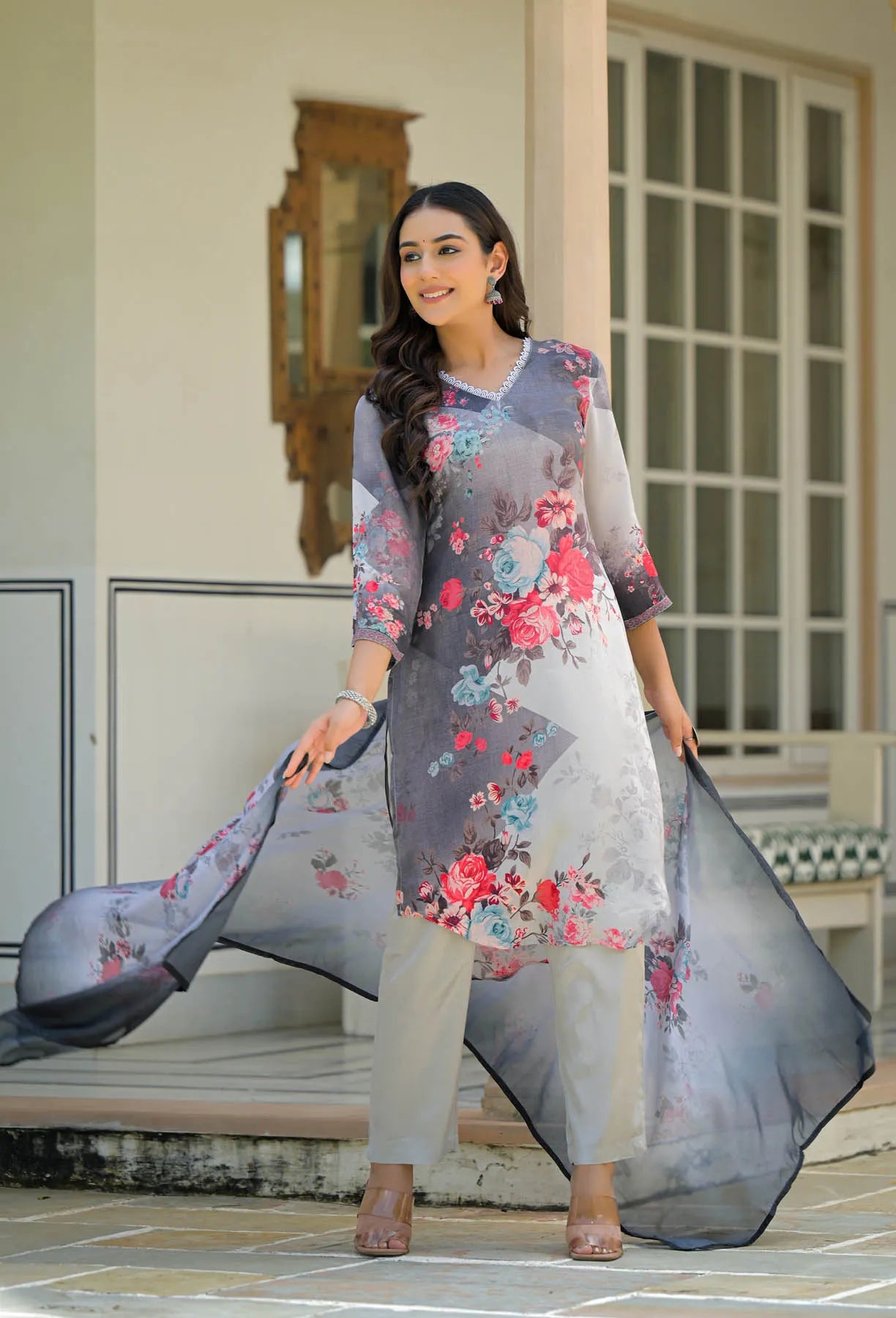 Woman wearing a floral dress with a long scarf in an outdoor setting