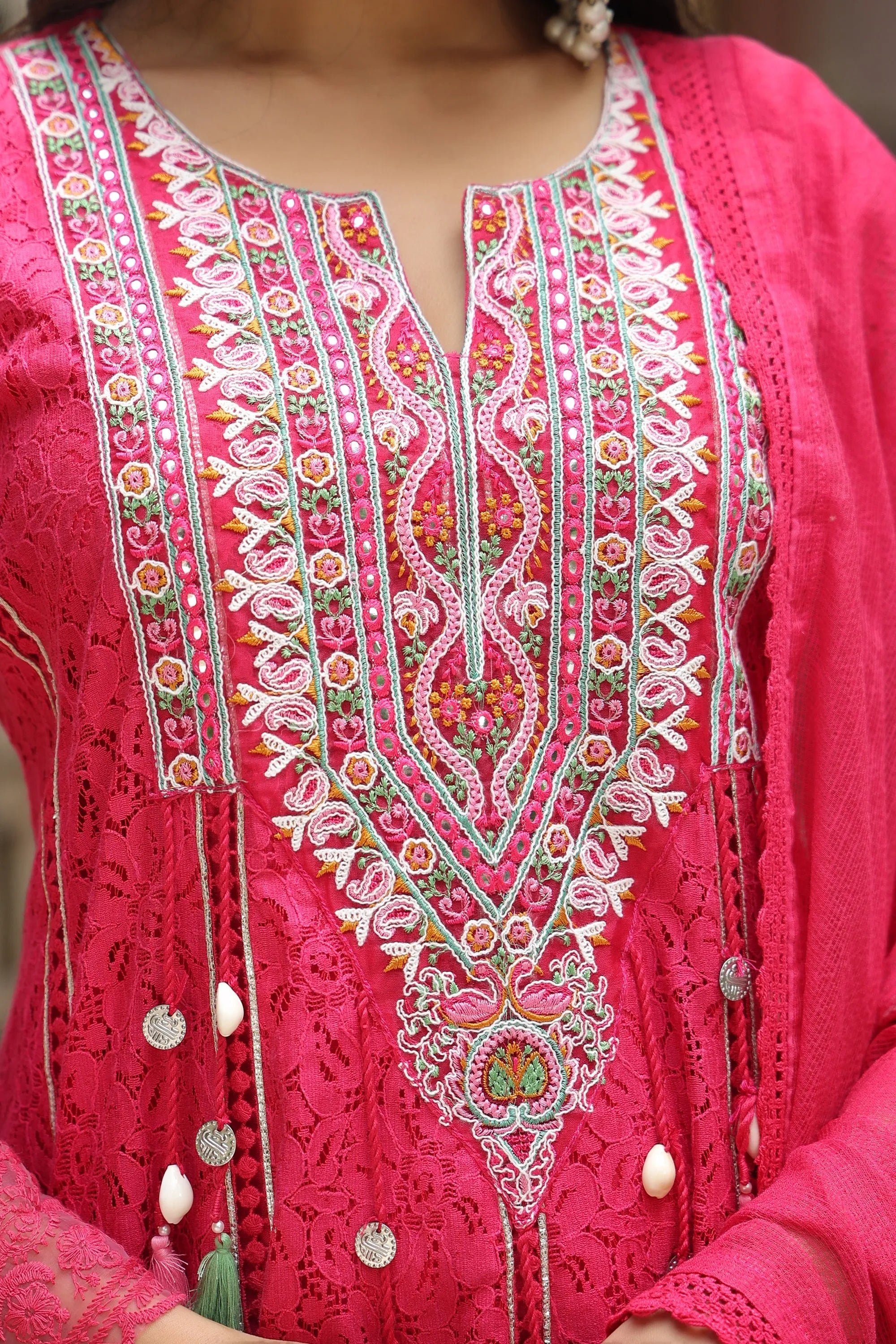 Close-up of a pink embroidered garment with intricate patterns