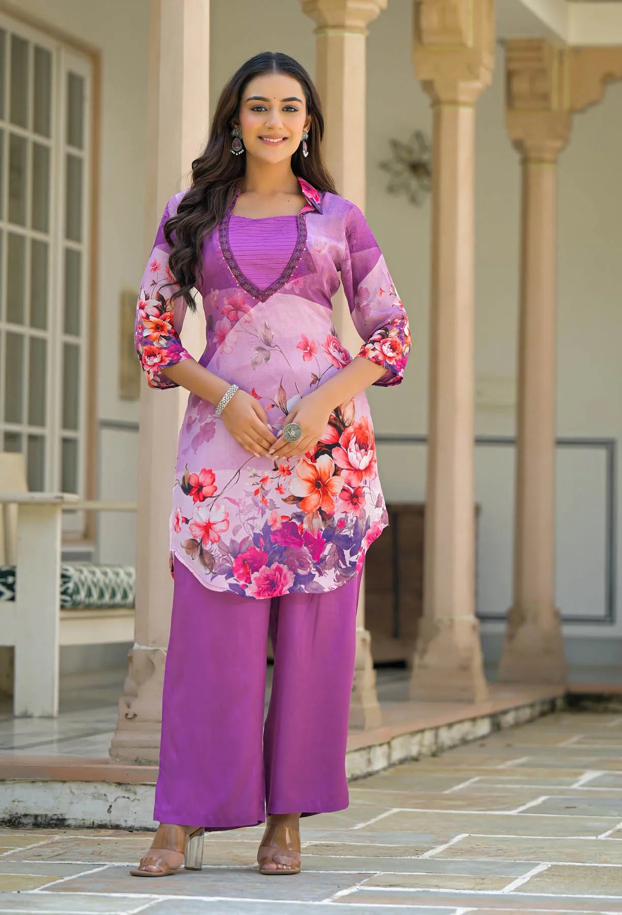 Woman wearing a floral dress with a purple outfit in an outdoor setting