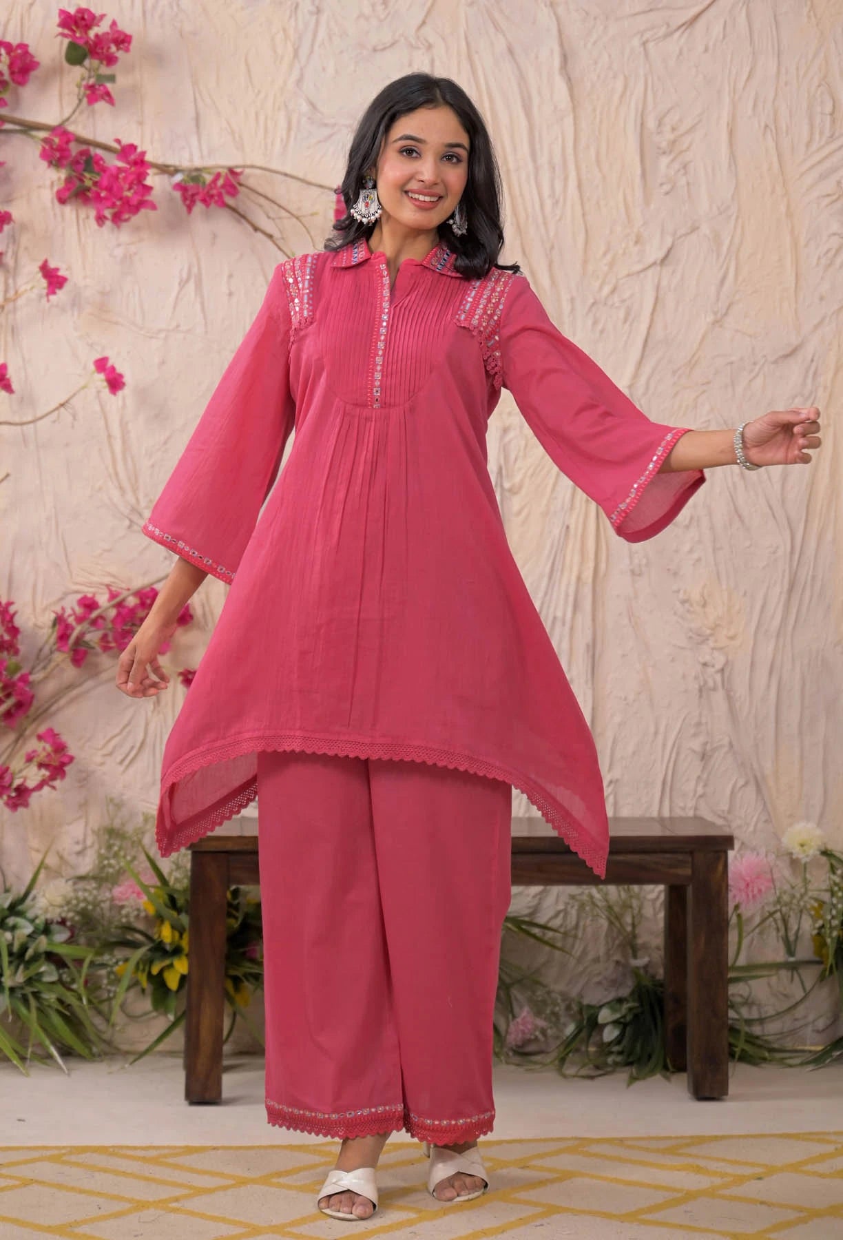 Woman wearing a pink traditional outfit with a floral background