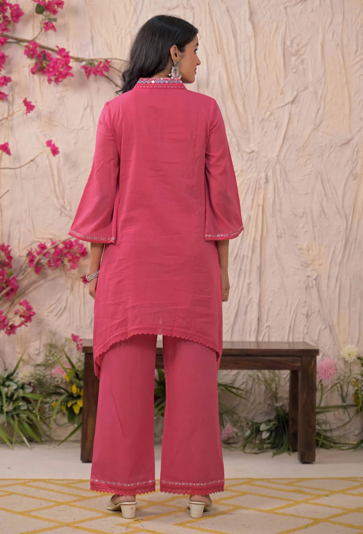 Woman wearing a pink traditional outfit with a floral background
