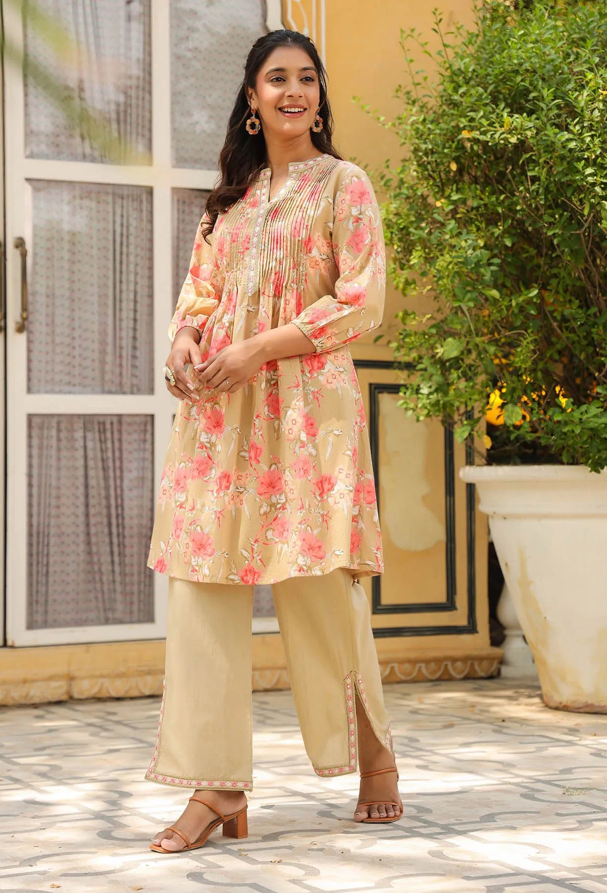 Woman wearing a floral kurta with beige pants outdoors.