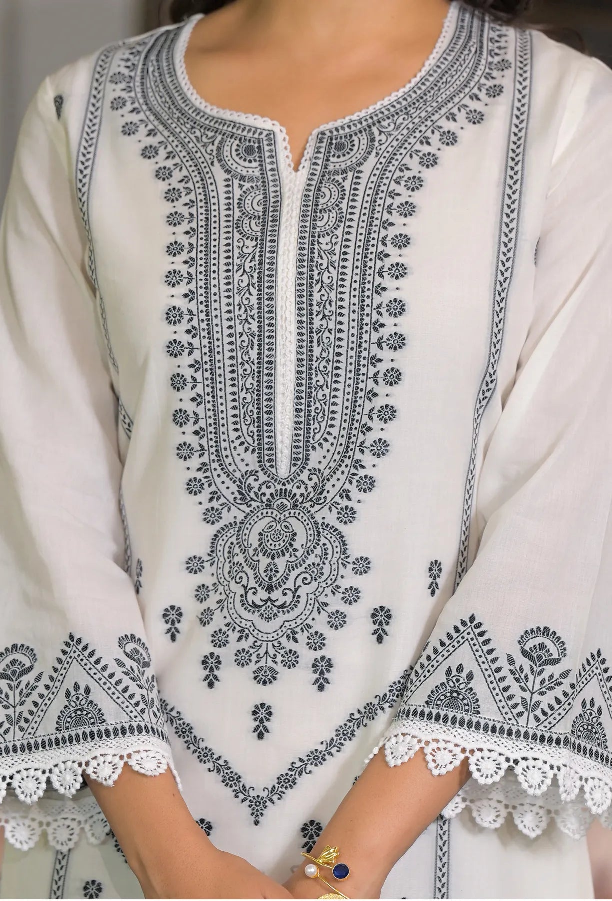 White embroidered garment with intricate black patterns