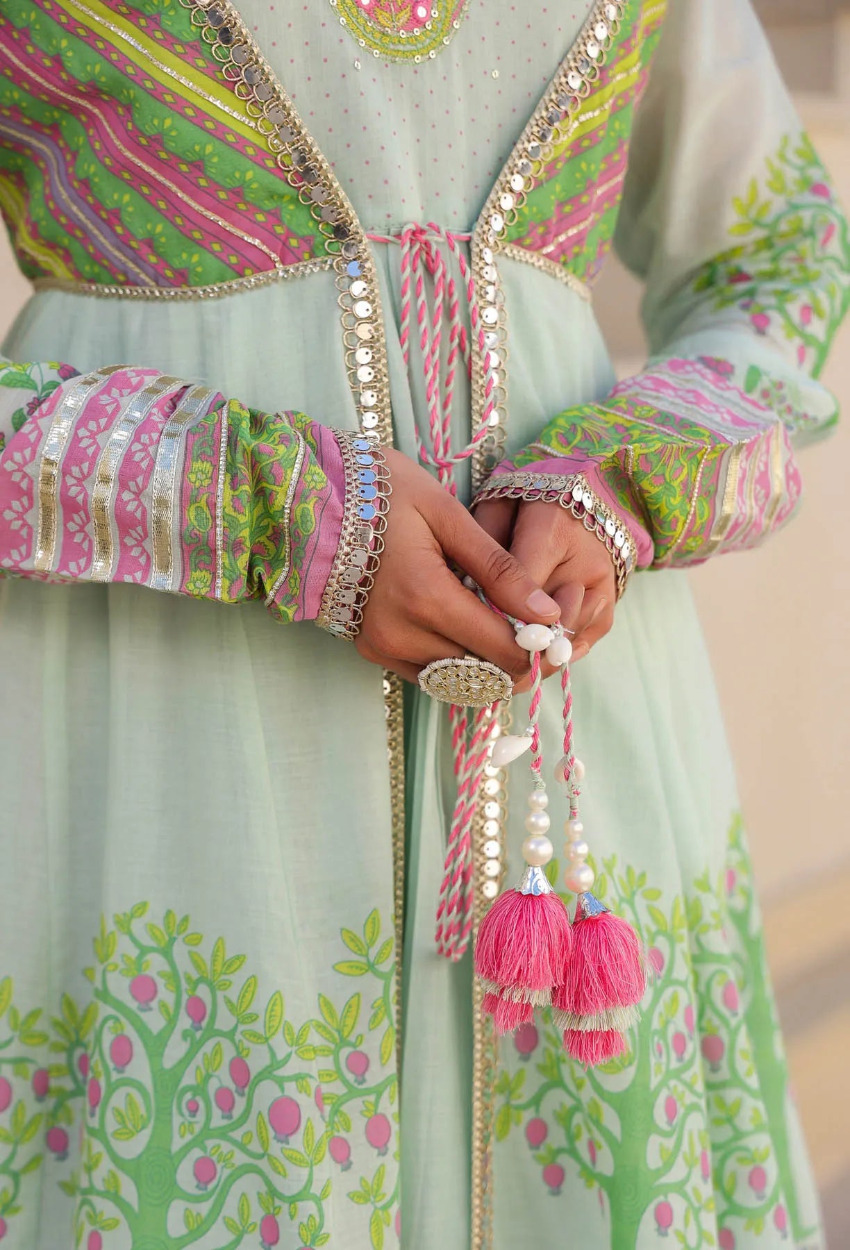 Close-up of a traditional outfit with colorful patterns and tassels.
