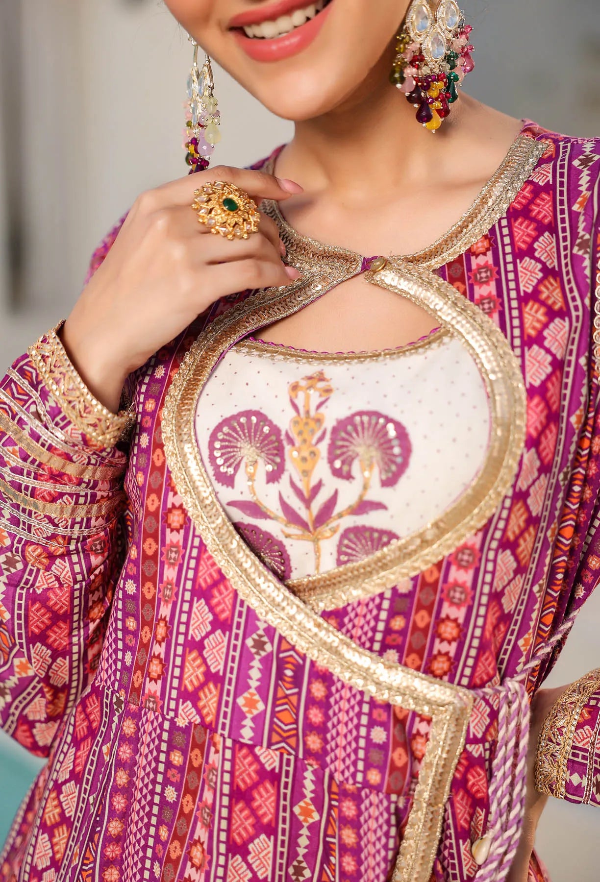 Close-up of a person wearing a vibrant, patterned traditional outfit with jewelry.
