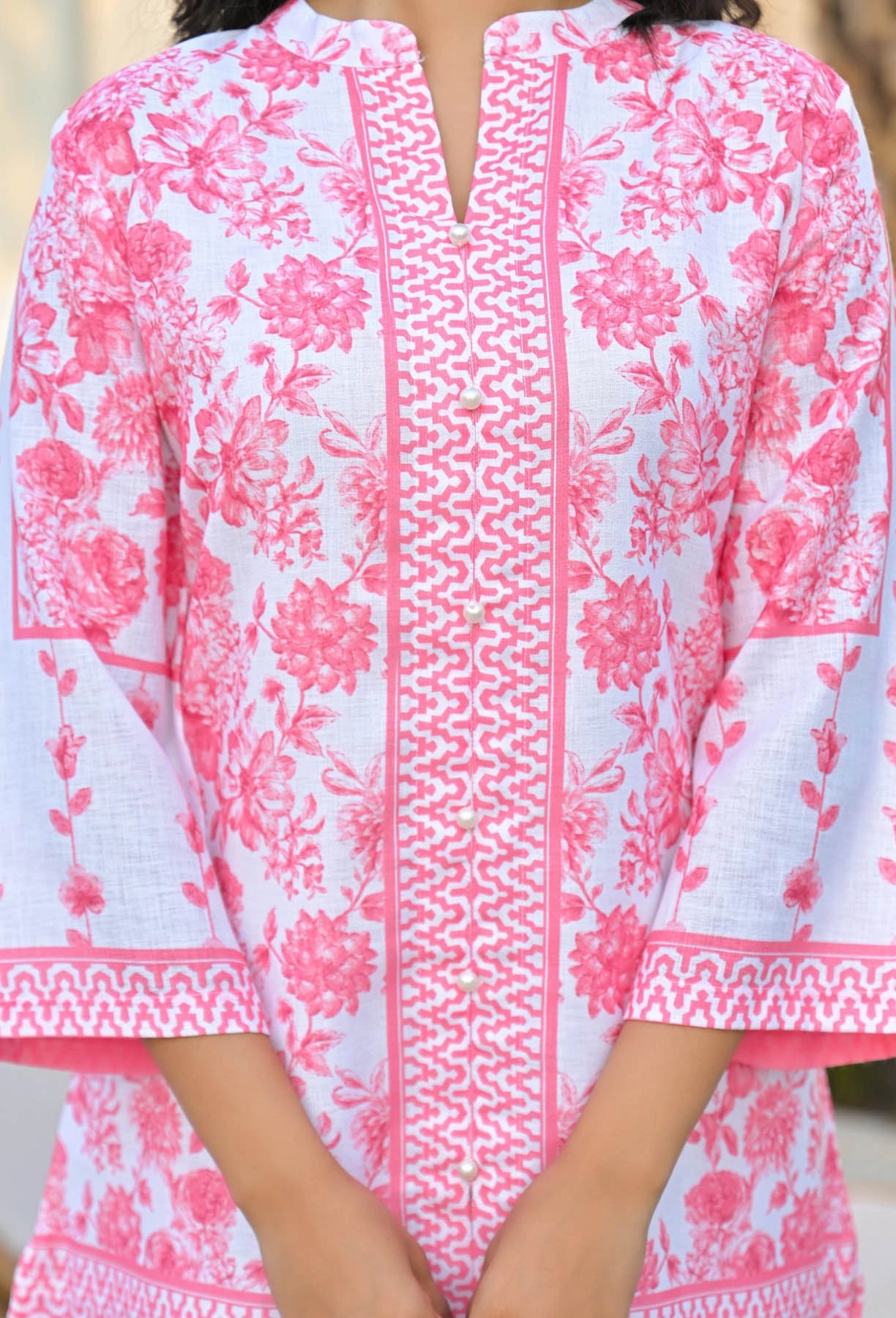 Pink and white floral patterned dress with intricate detailing
