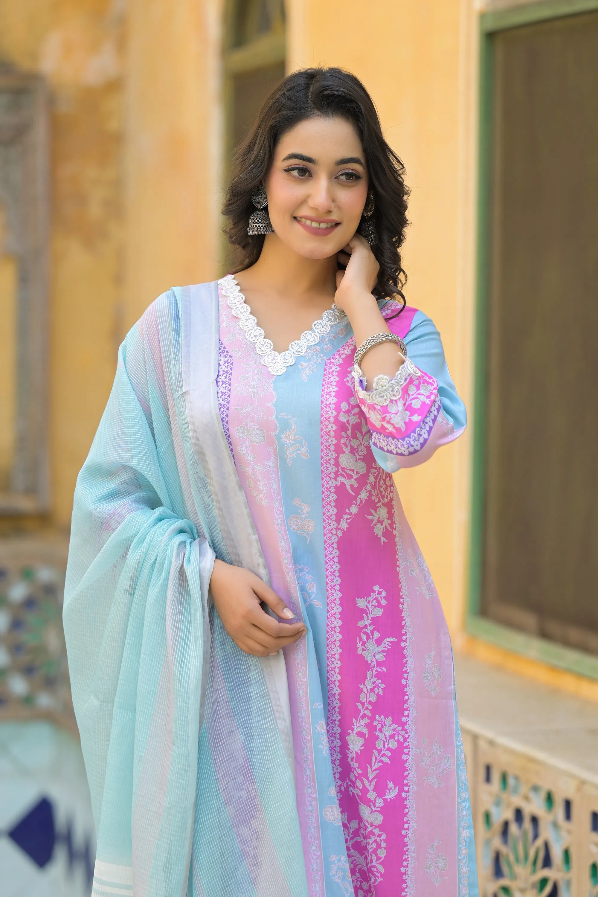 Woman wearing a colorful traditional outfit with a pastel color scheme.