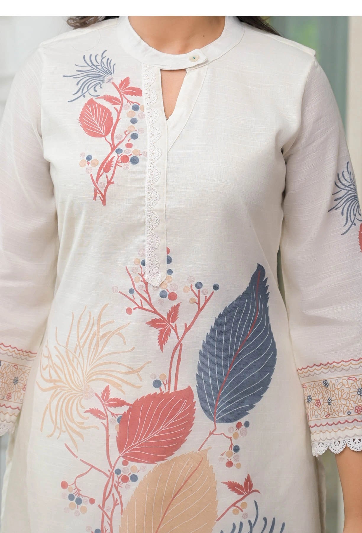 White kurta with colorful floral embroidery on a blurred background