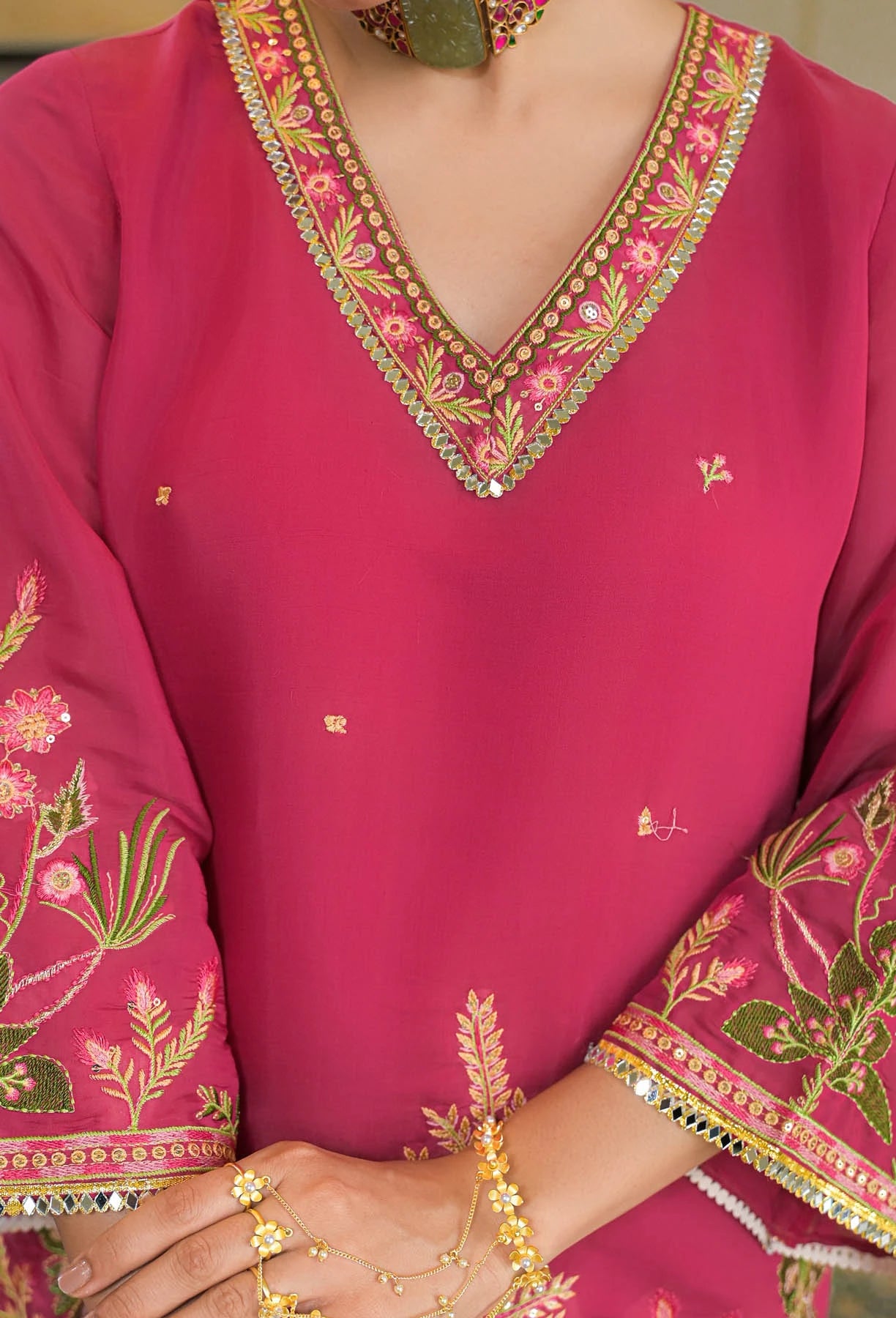 Close-up of a pink embroidered garment with intricate patterns