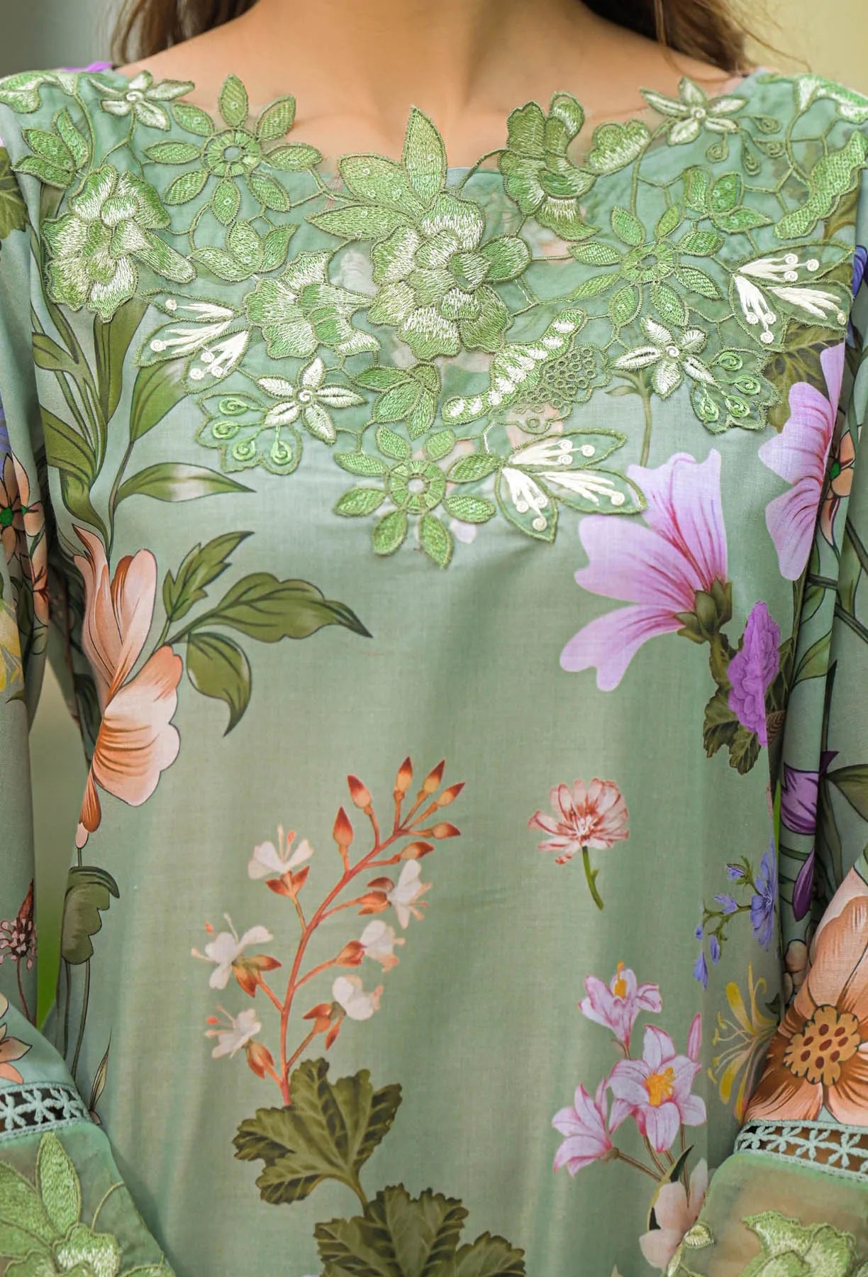 Floral patterned fabric with green leaves and colorful flowers on a light green background