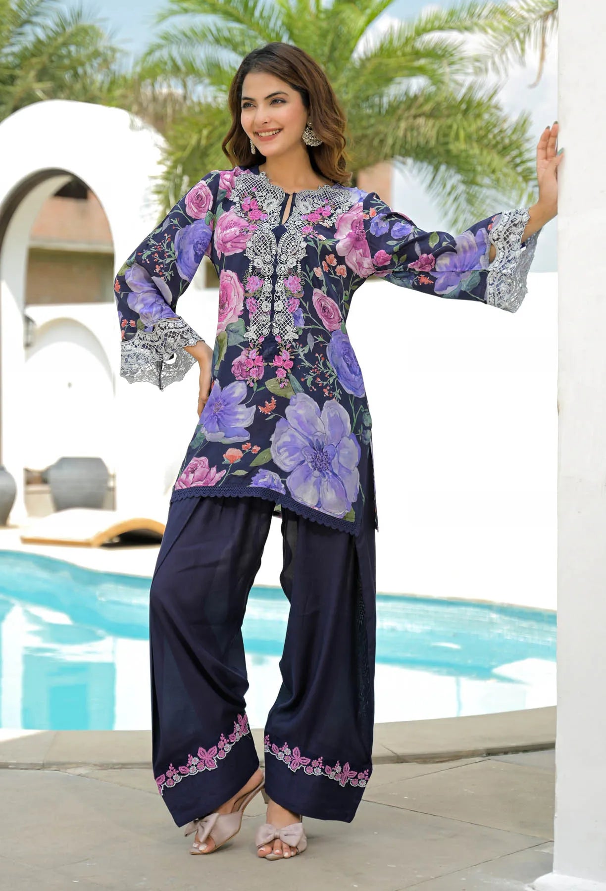 Woman wearing a floral embroidered outfit by a poolside